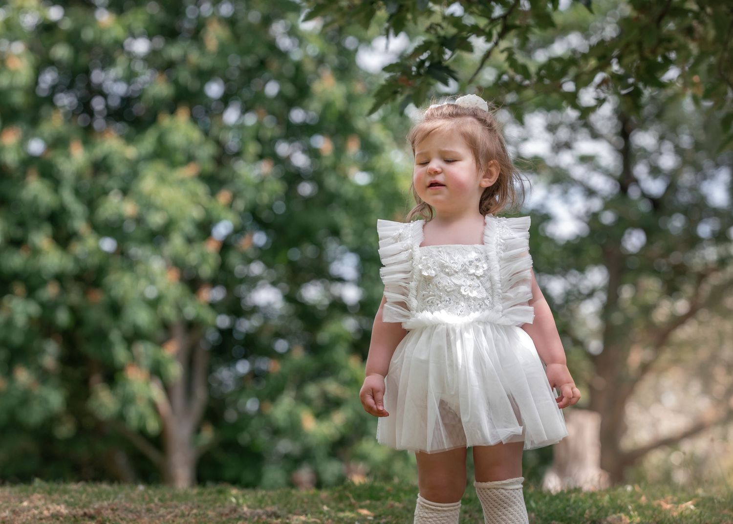 Toddler girl in white tulle dress standing outdoors in east park.
east yorkshire child photography