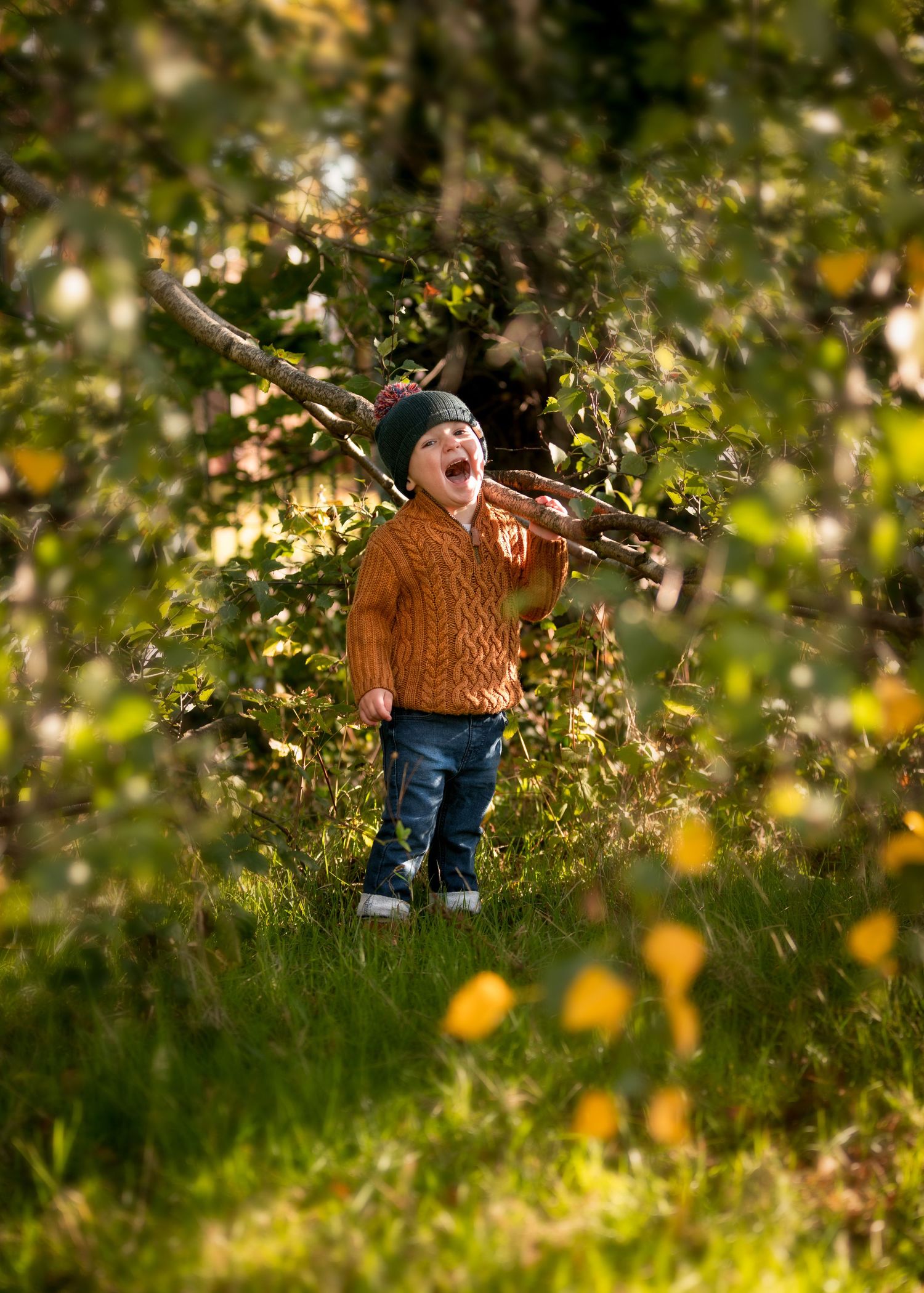 Excited toddler in orange knit sweater and beanie hat playing with stick among autumn foliage.

Sutton Village Hull