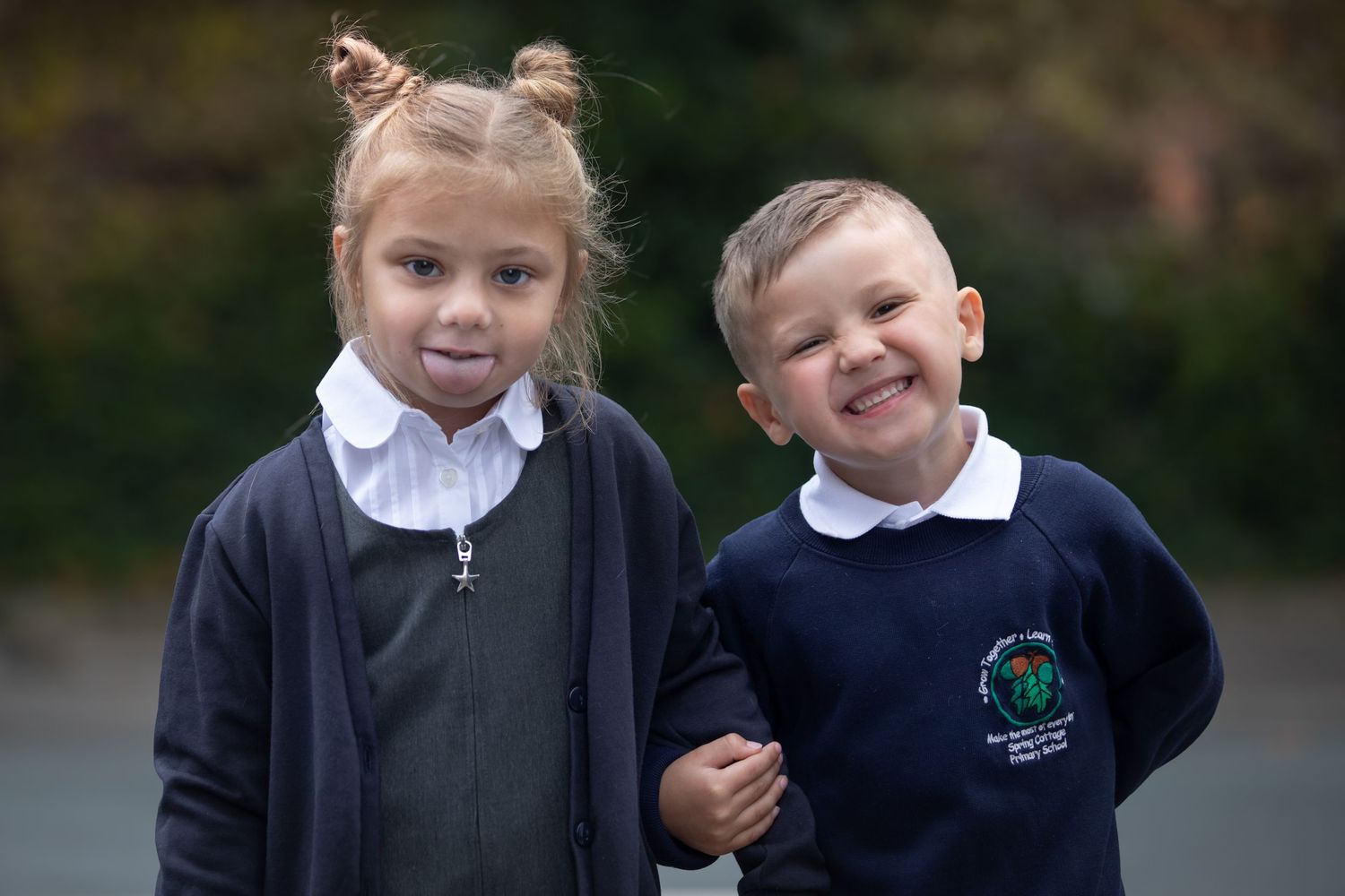 Two young children in school uniforms smiling outdoors, a girl and boy posing together on a playground.

Sutton Village Hull