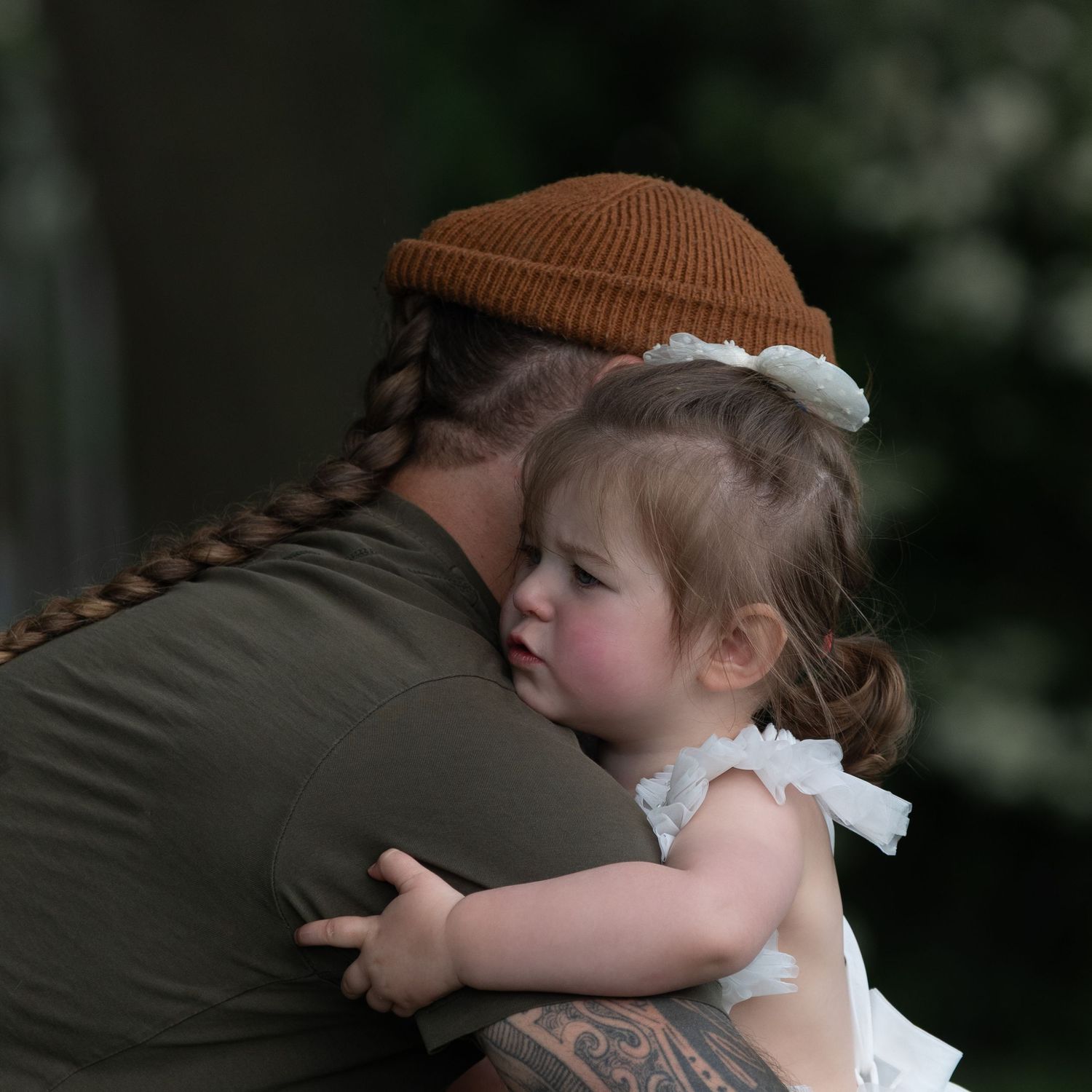 A tattooed man with a braided ponytail and brown beanie tenderly hugs a toddler girl wearing a white bow in her hair.

East Park Hull