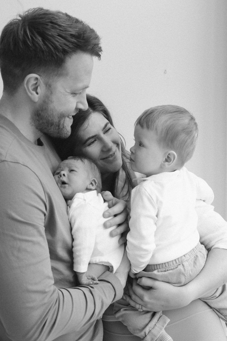 Sweet black and white family portrait showing tender moments between a family with two young children.