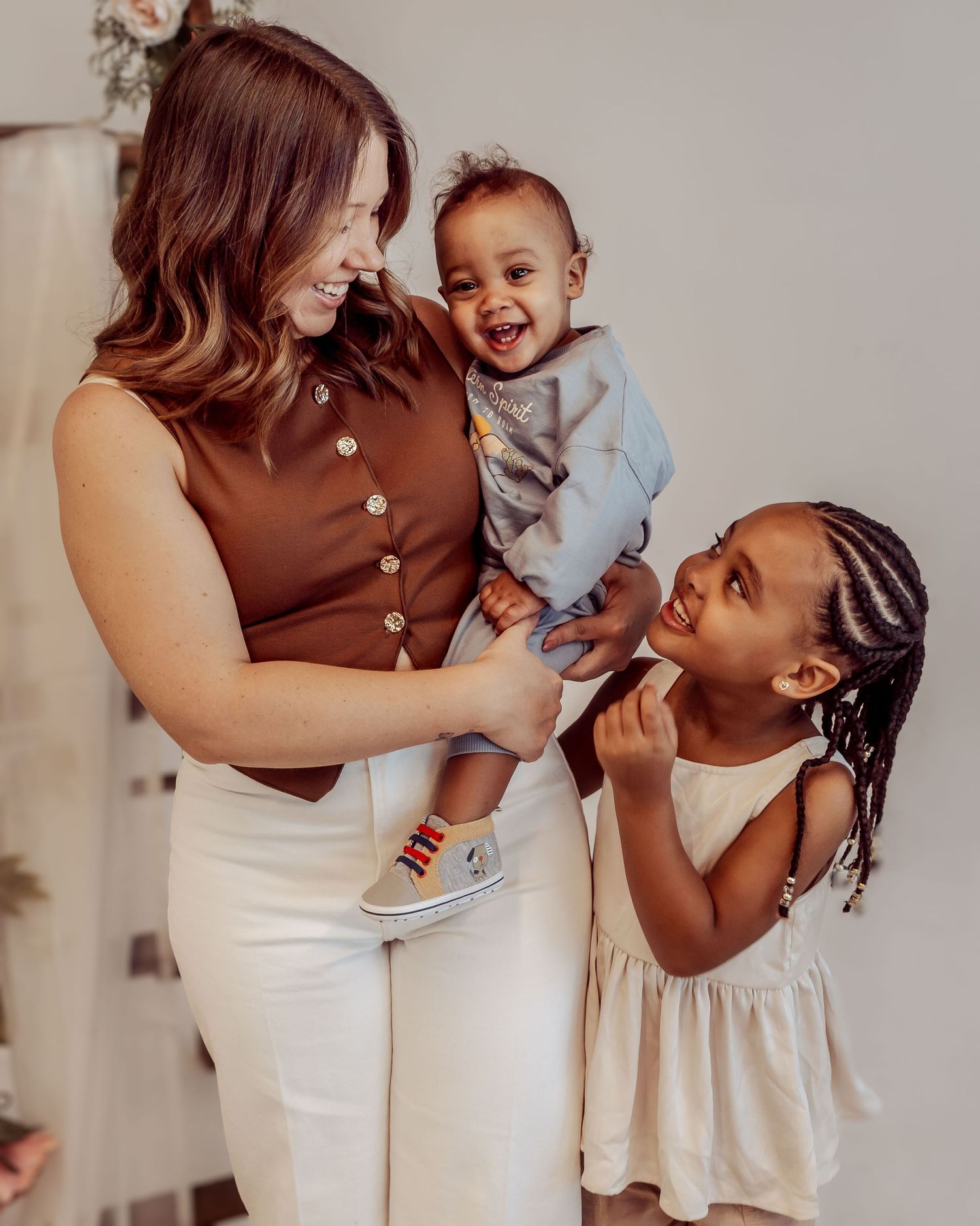 Family sharing joyful moments together in casual white and brown outfits.