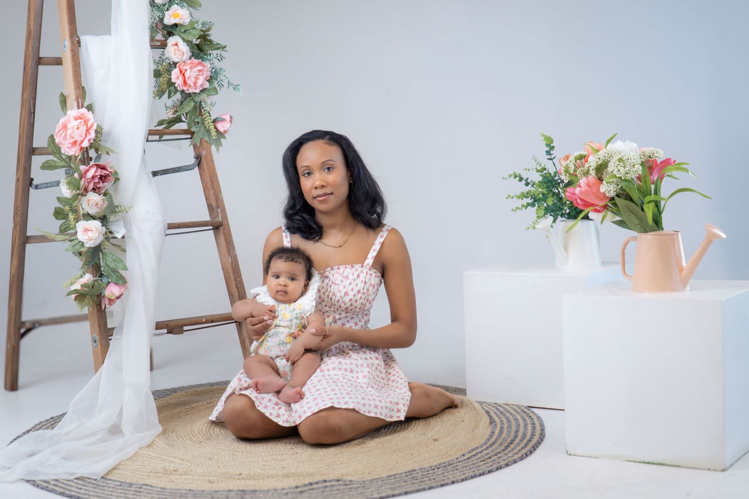 A bright studio setting with decorative wooden ladder, floral arrangements, and white decor elements.