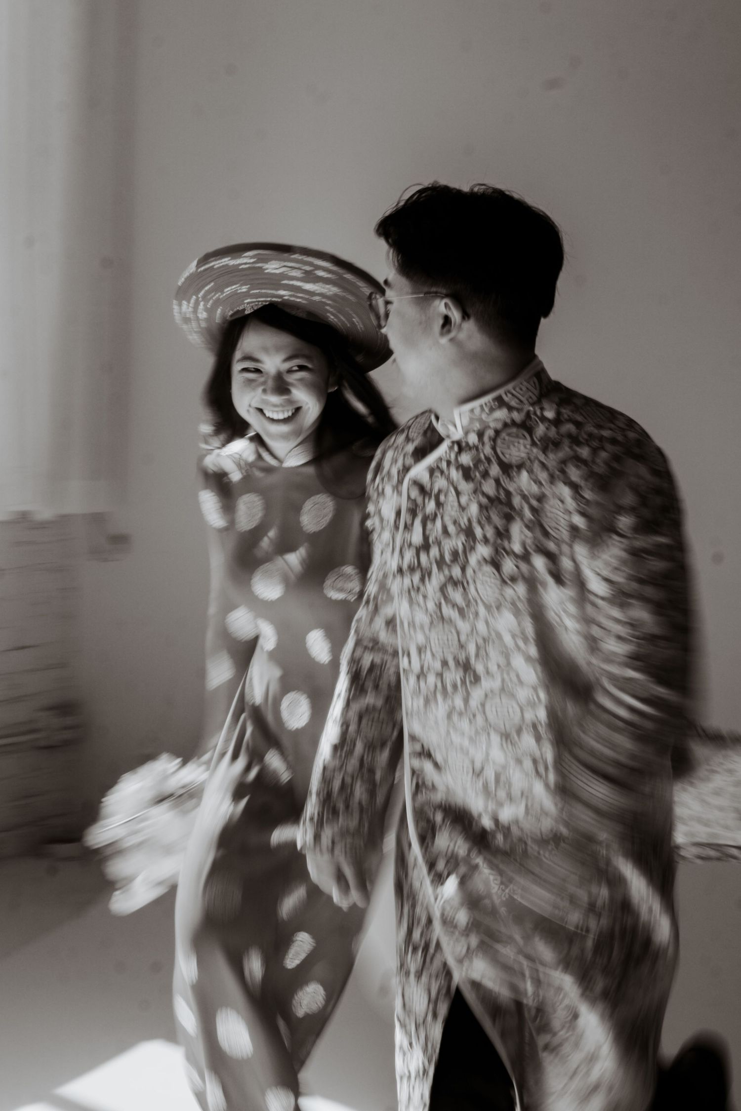 A black and white photo sequence shows two figures dancing together in flowing motion against a light background.