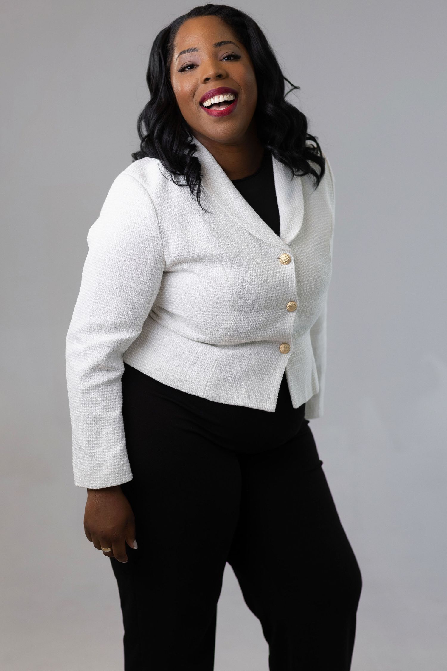 A professional photo series showing a model wearing a stylish white blazer with gold buttons paired with black pants.