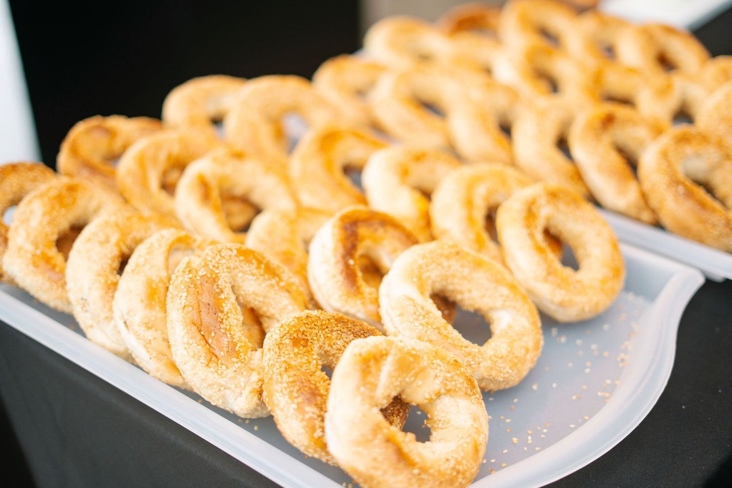 Golden crispy onion rings arranged in neat rows on a white serving platter.