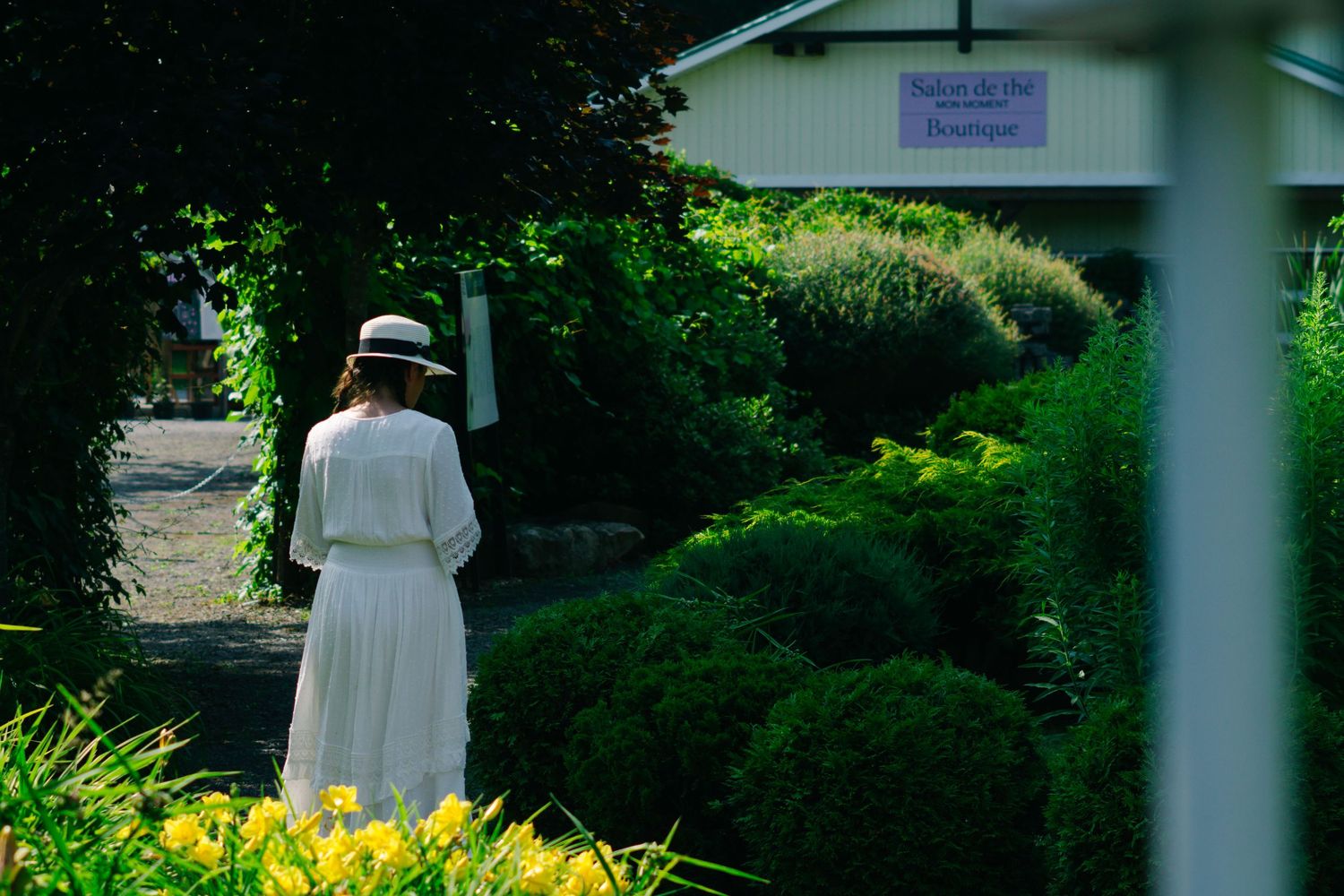 A serene garden path with white architectural elements and lush greenery creating a peaceful walkway.
