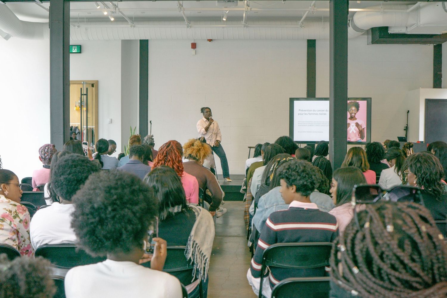 Audience members seated in rows during a professional conference or seminar presentation.
