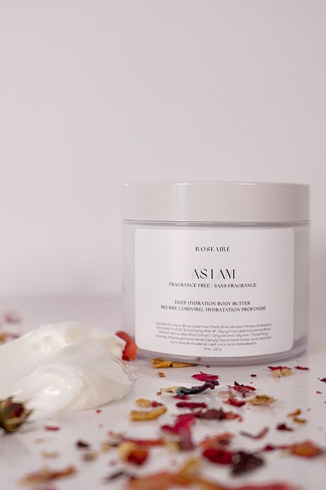 White skincare product jar with dried flower petals scattered on a light surface in a minimalist beauty product display.