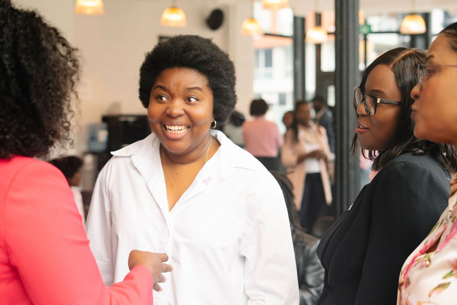 A group of people engaged in lively conversation at an indoor social gathering.