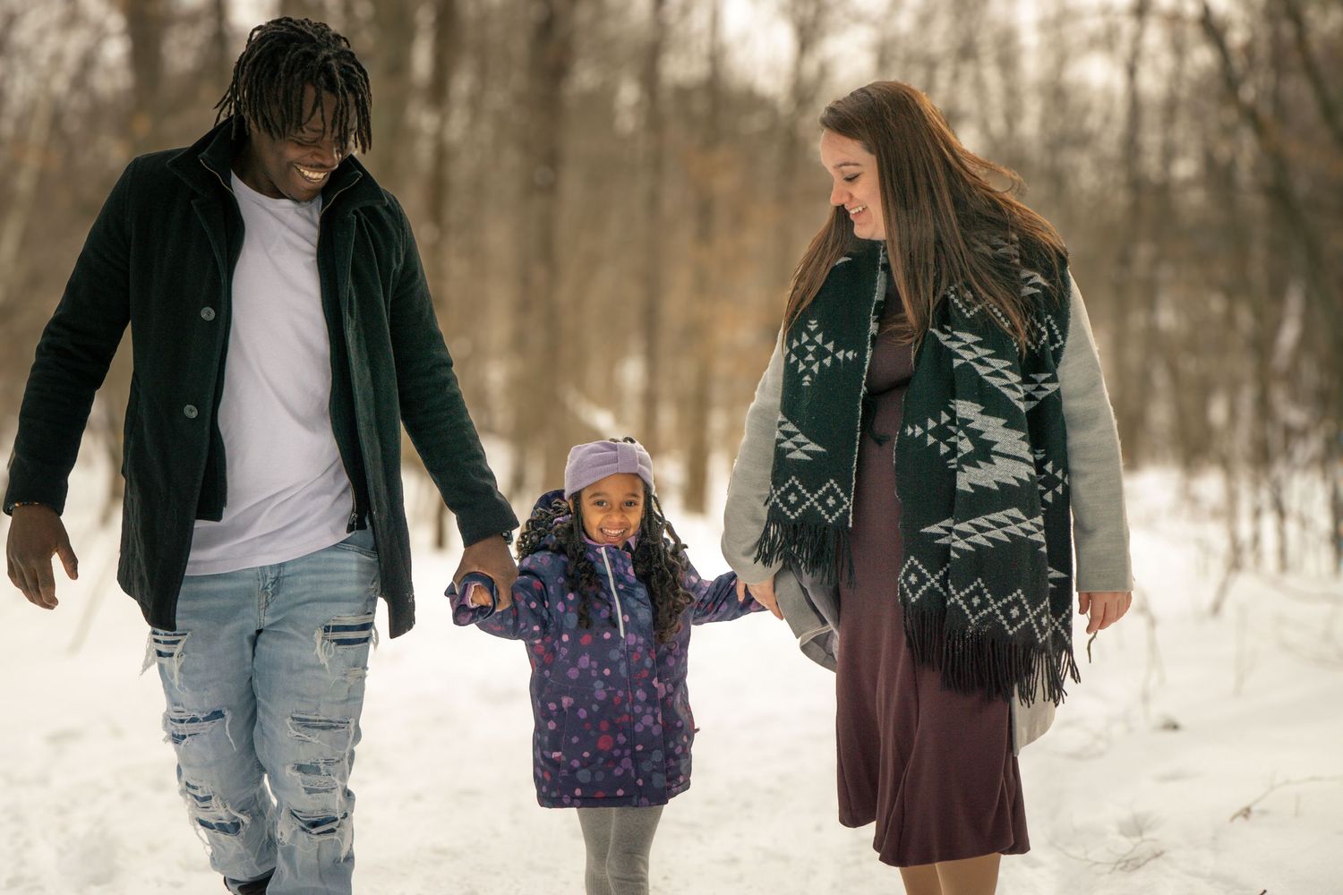 Friends walking together through snowy winter landscape during outdoor photoshoot.