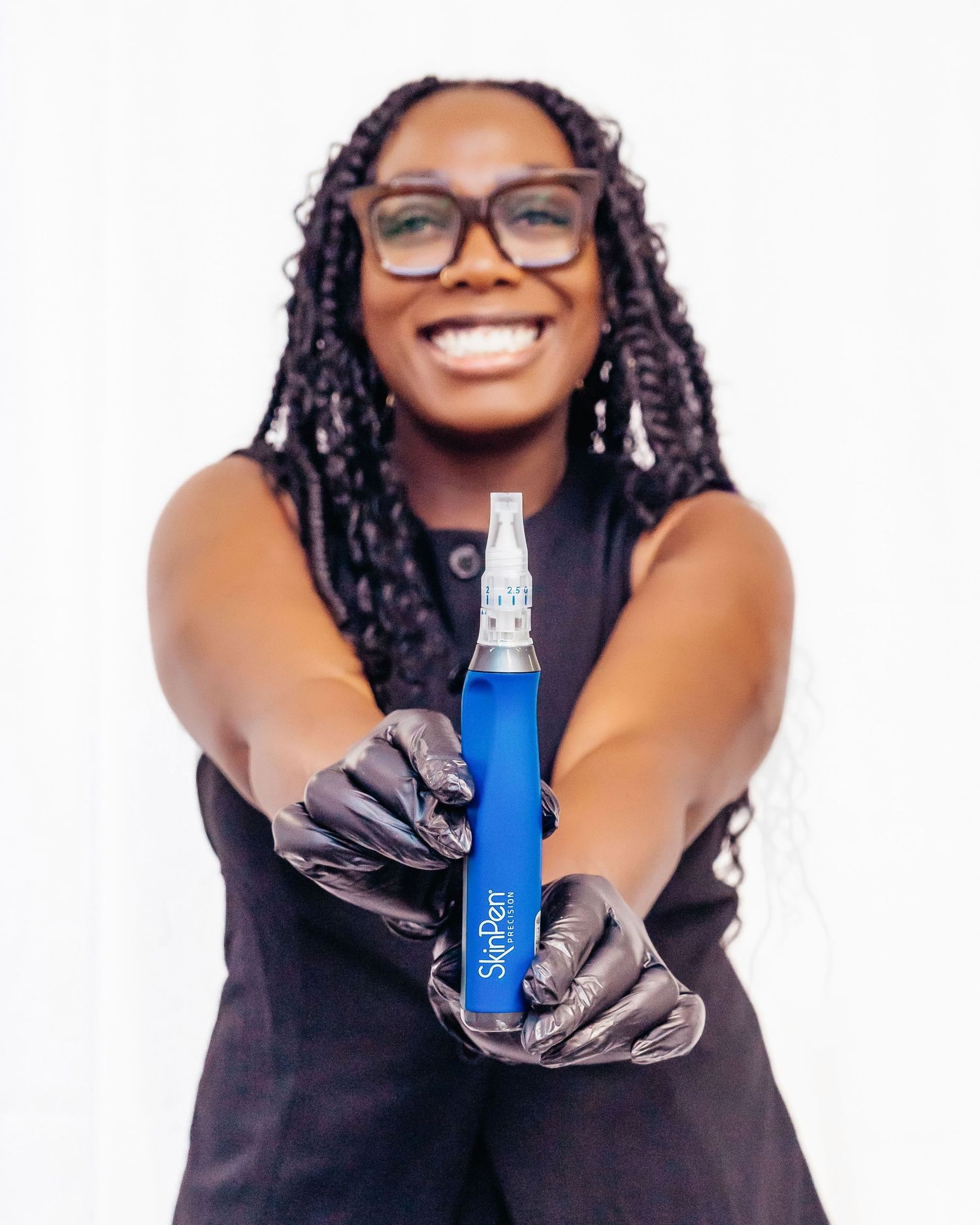 A collage of four similar photos showing someone in black attire holding a blue bottle against a white background.