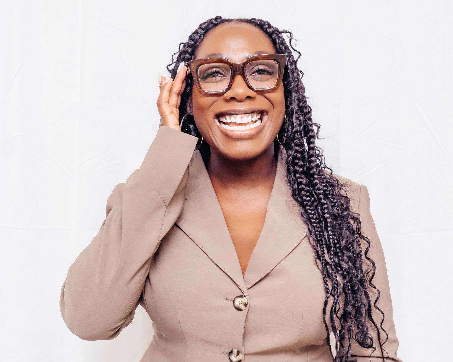 Professional headshots of someone wearing glasses and a beige blazer while smiling warmly at the camera.