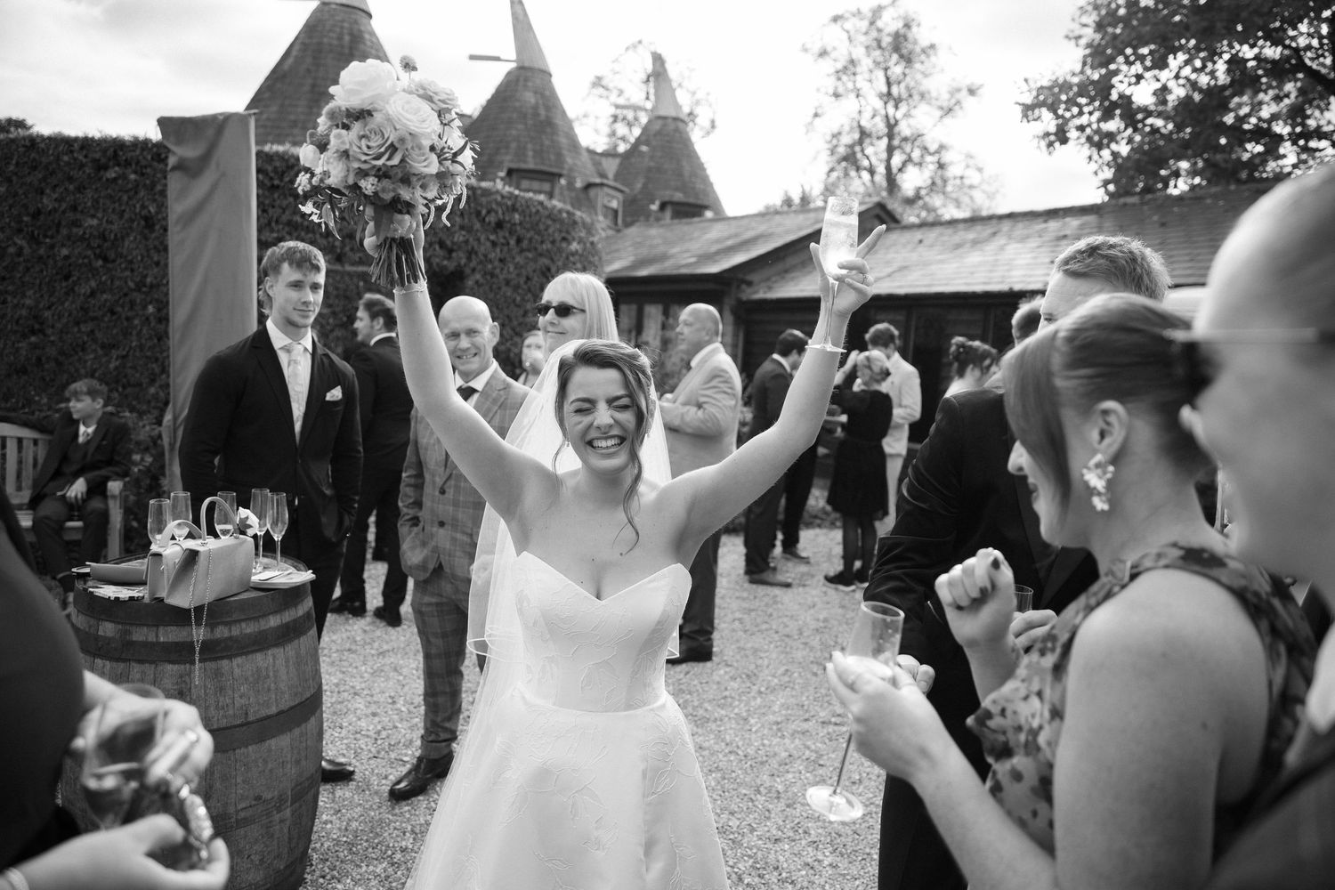 A candid moment of a Bride celebrating at her wedding, black and white image, photographed by Maddie Waters Hampshire wedding photographer