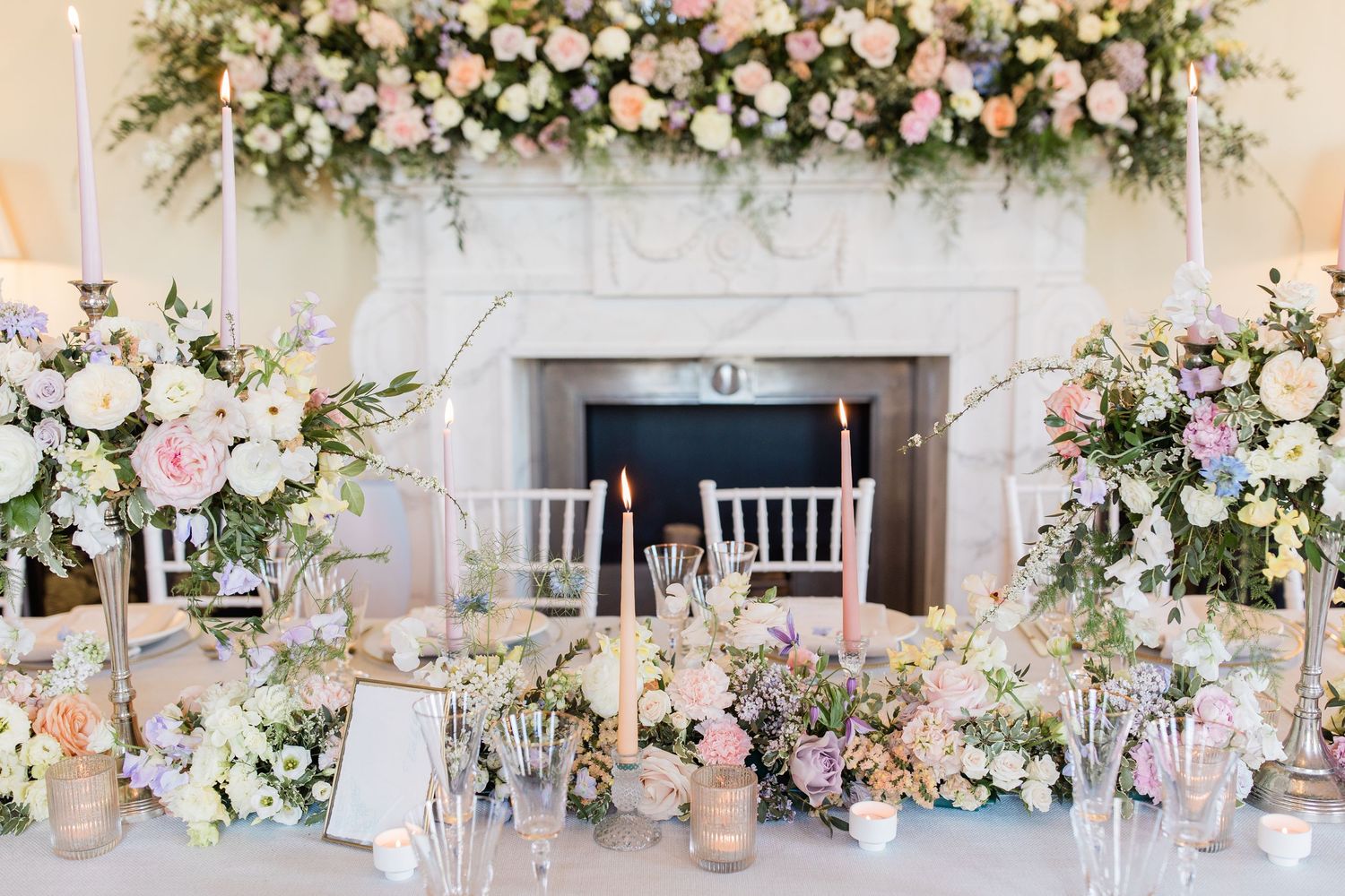 Elegant wedding reception decor with pink and white floral arrangements cascading along tables and archways.