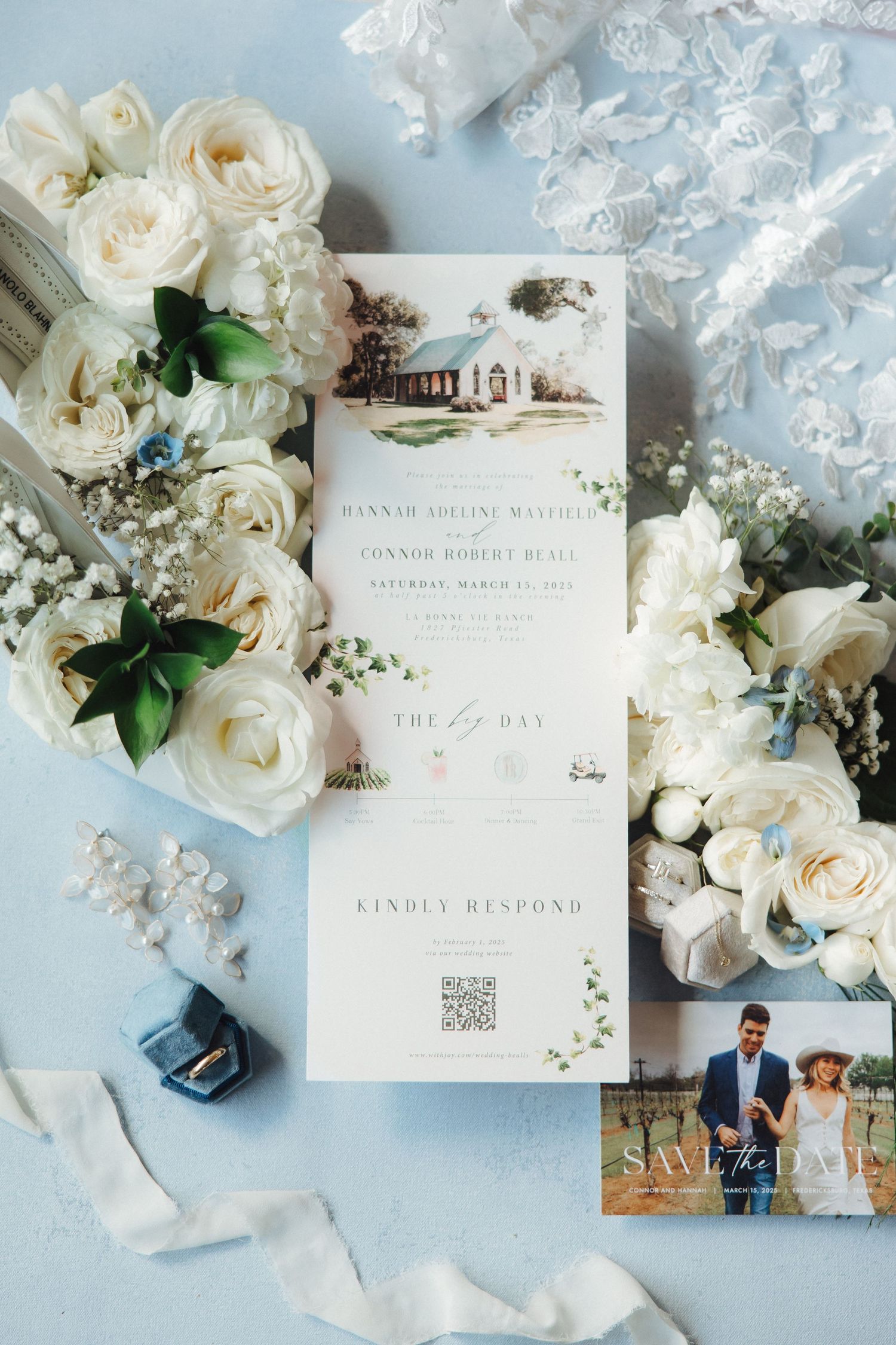 Wedding invitation with venue illustration surrounded by white roses, lace, and floral details.