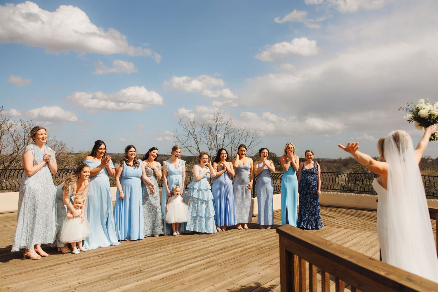 A collage of wedding party photos shows bridesmaids in light blue dresses posing with the bride on a wooden boardwalk.