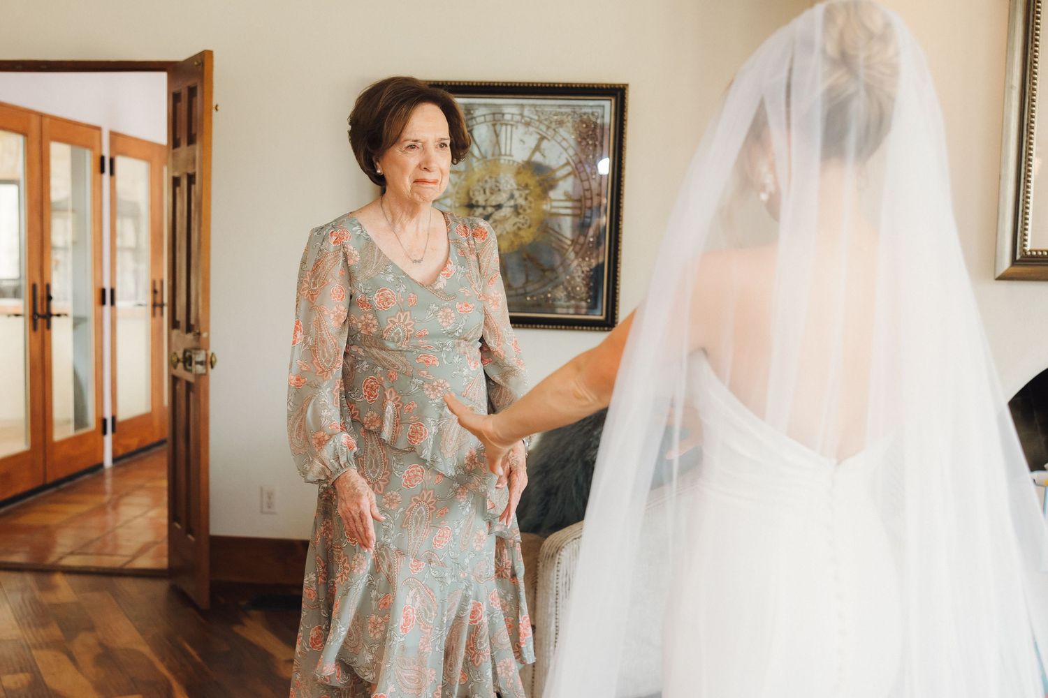 A bridal preparation sequence showing someone adjusting a flowing white wedding veil in an elegant indoor setting.