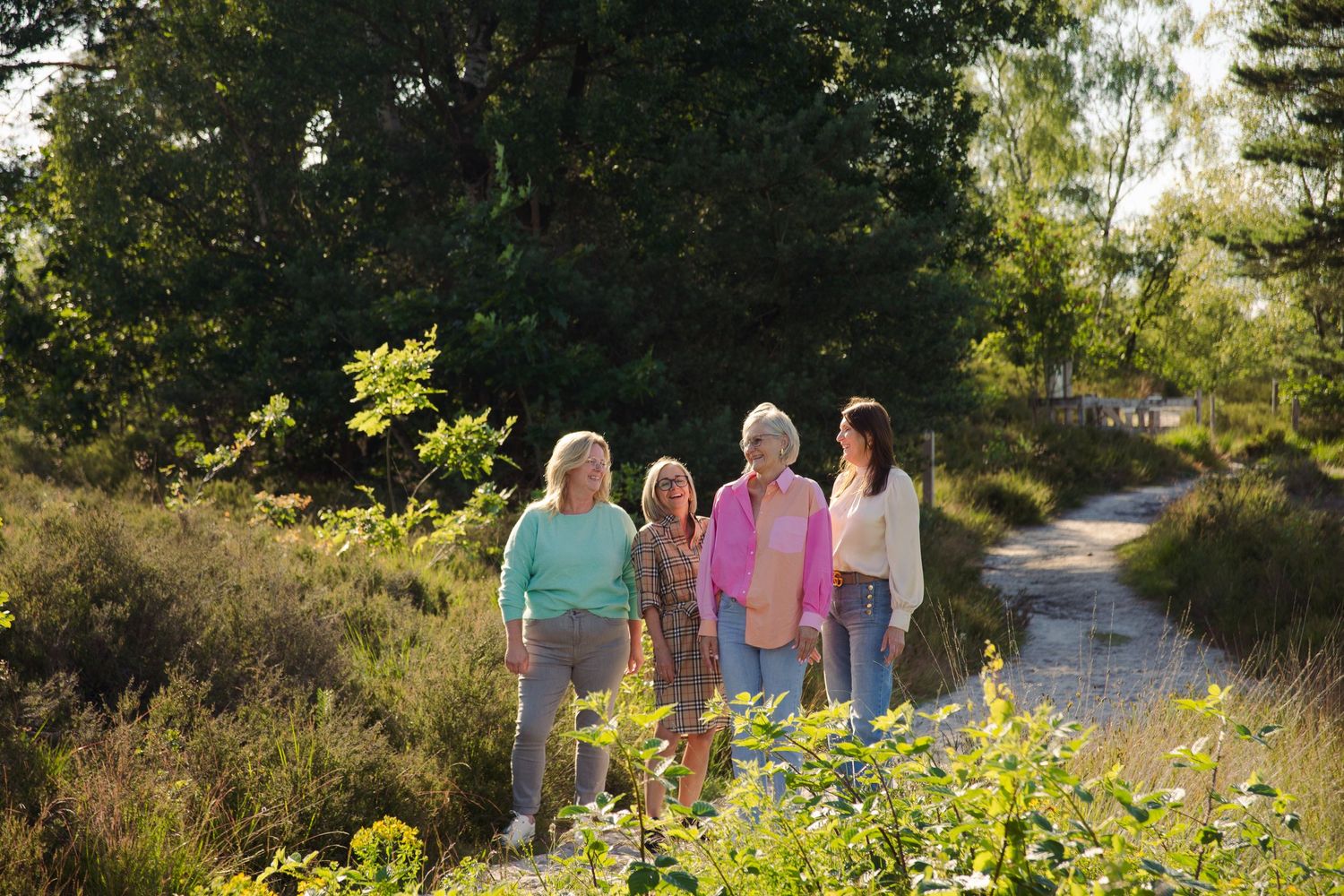 A candid image of a group of four women laughing in a group portrait photo in de Teut in Zonhoven.