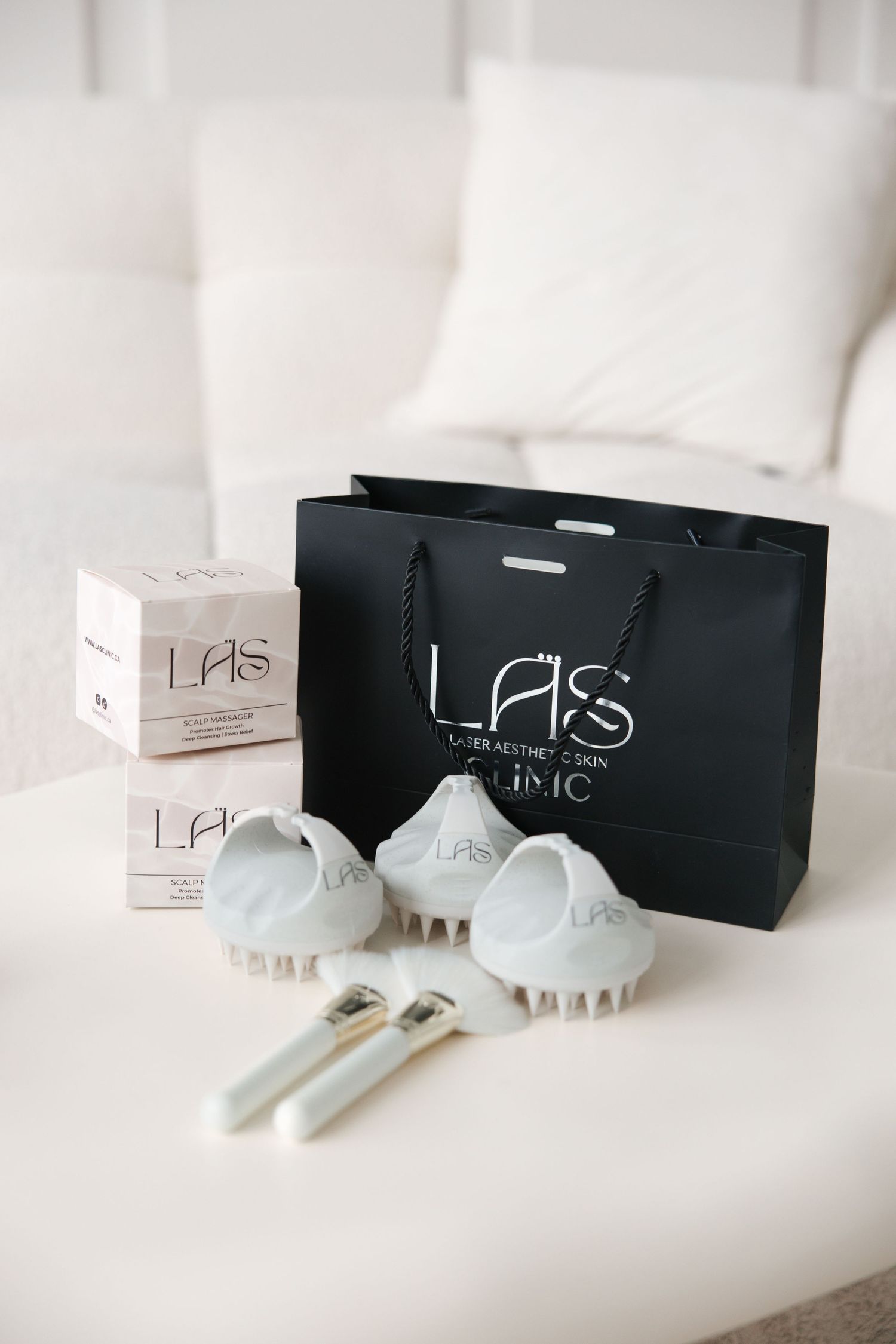 LAS Laser Aesthetics Skin Clinic branded black gift bag displayed with skincare products and tools.