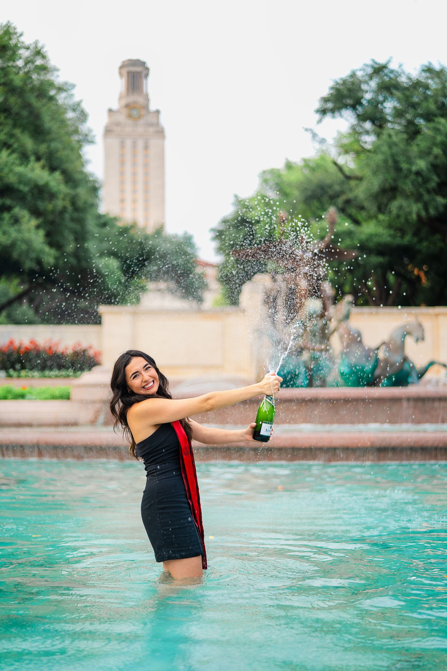 Senior champagne pop portrait at UT Austin’s Littlefield Fountain