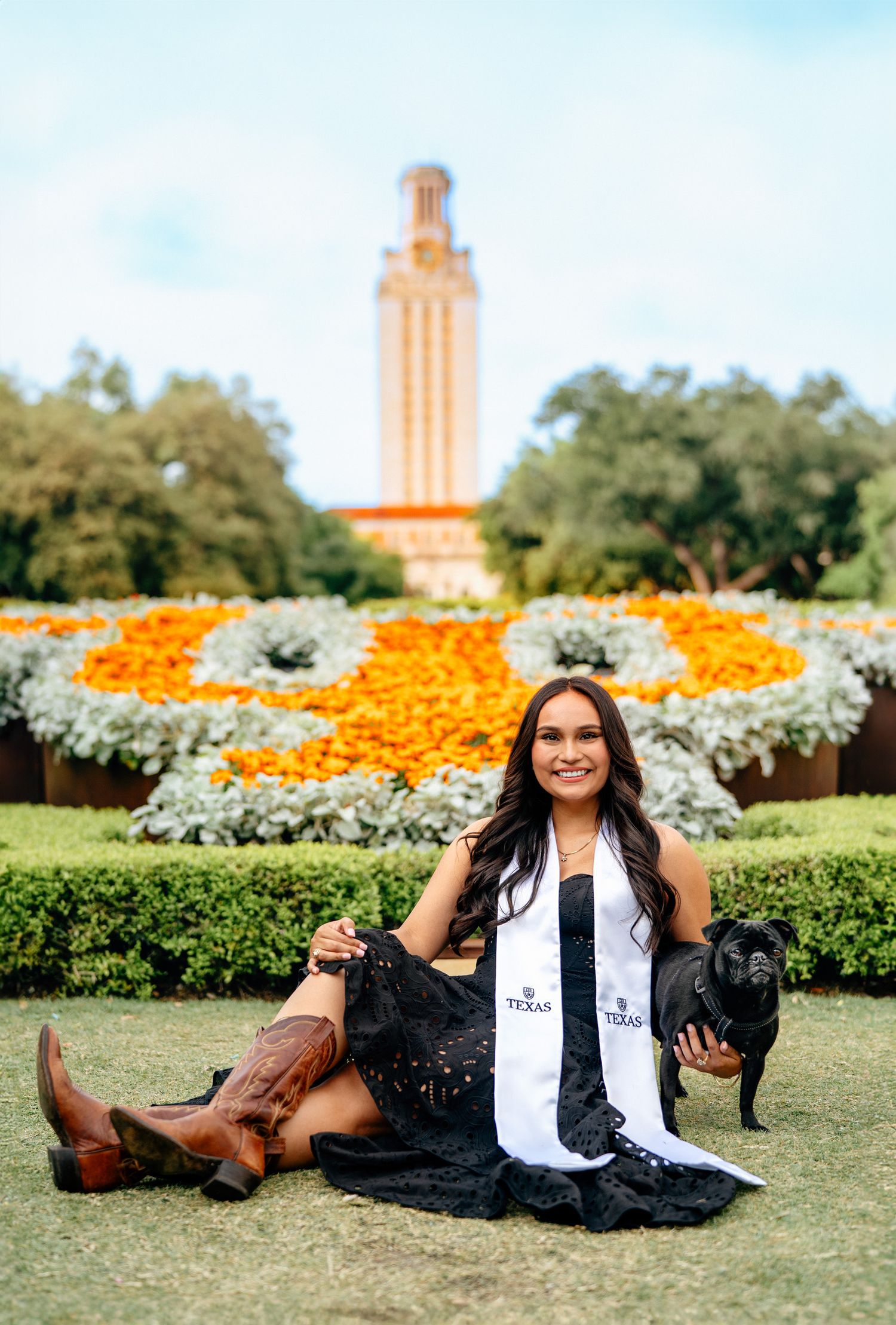 Graduation photos taken in front of the UT Austin Tower with orange and white wildflowers in bloom.