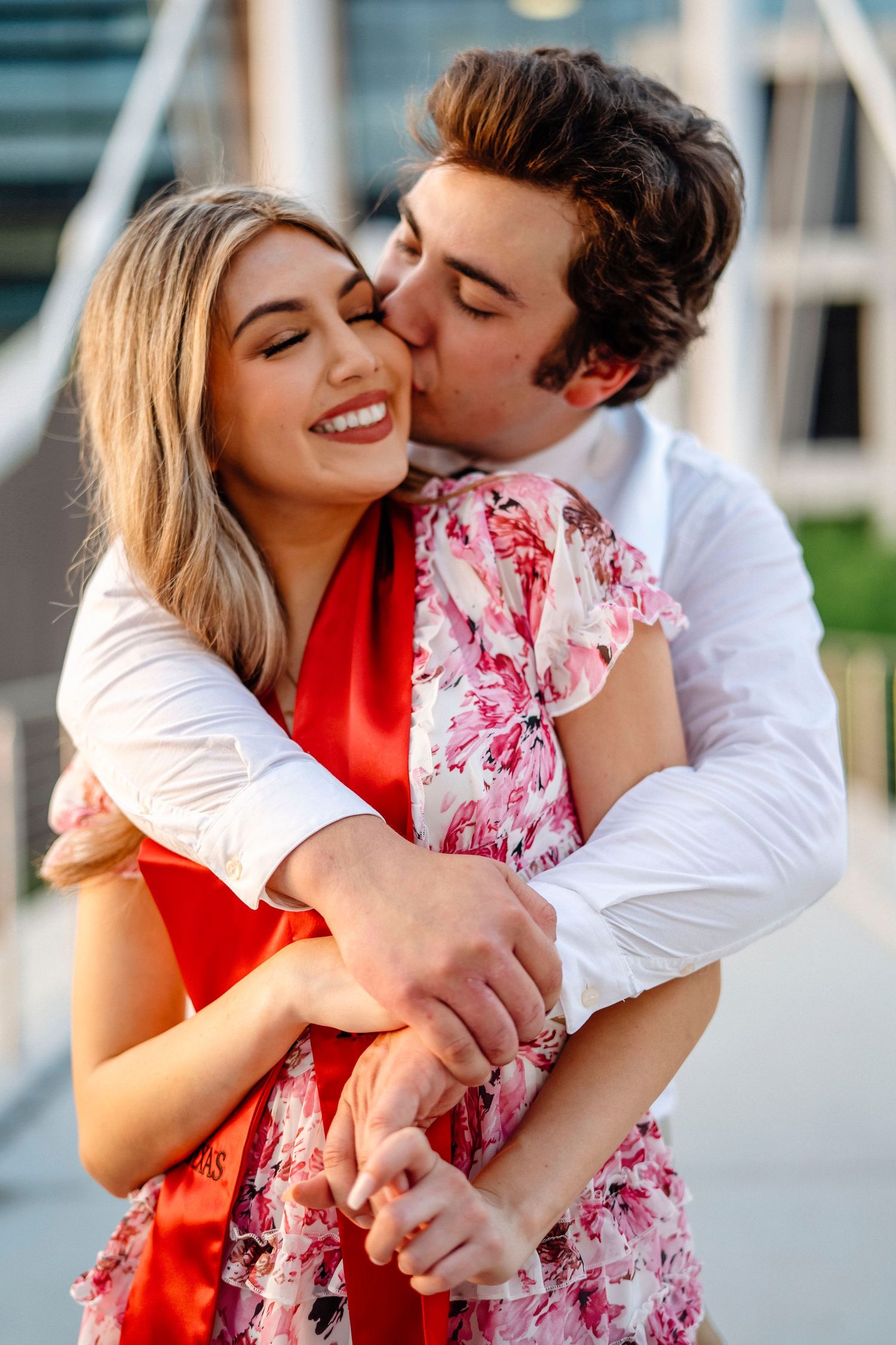 Couple shares romantic moment during graduation celebration.
