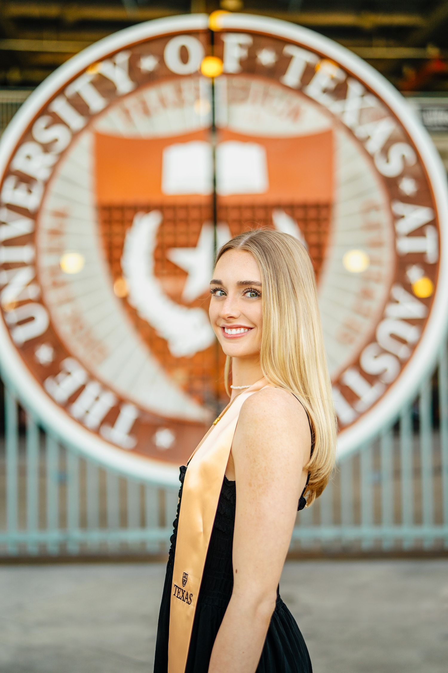 Senior portraits taken in front of vintage University of Texas seal and logo.
