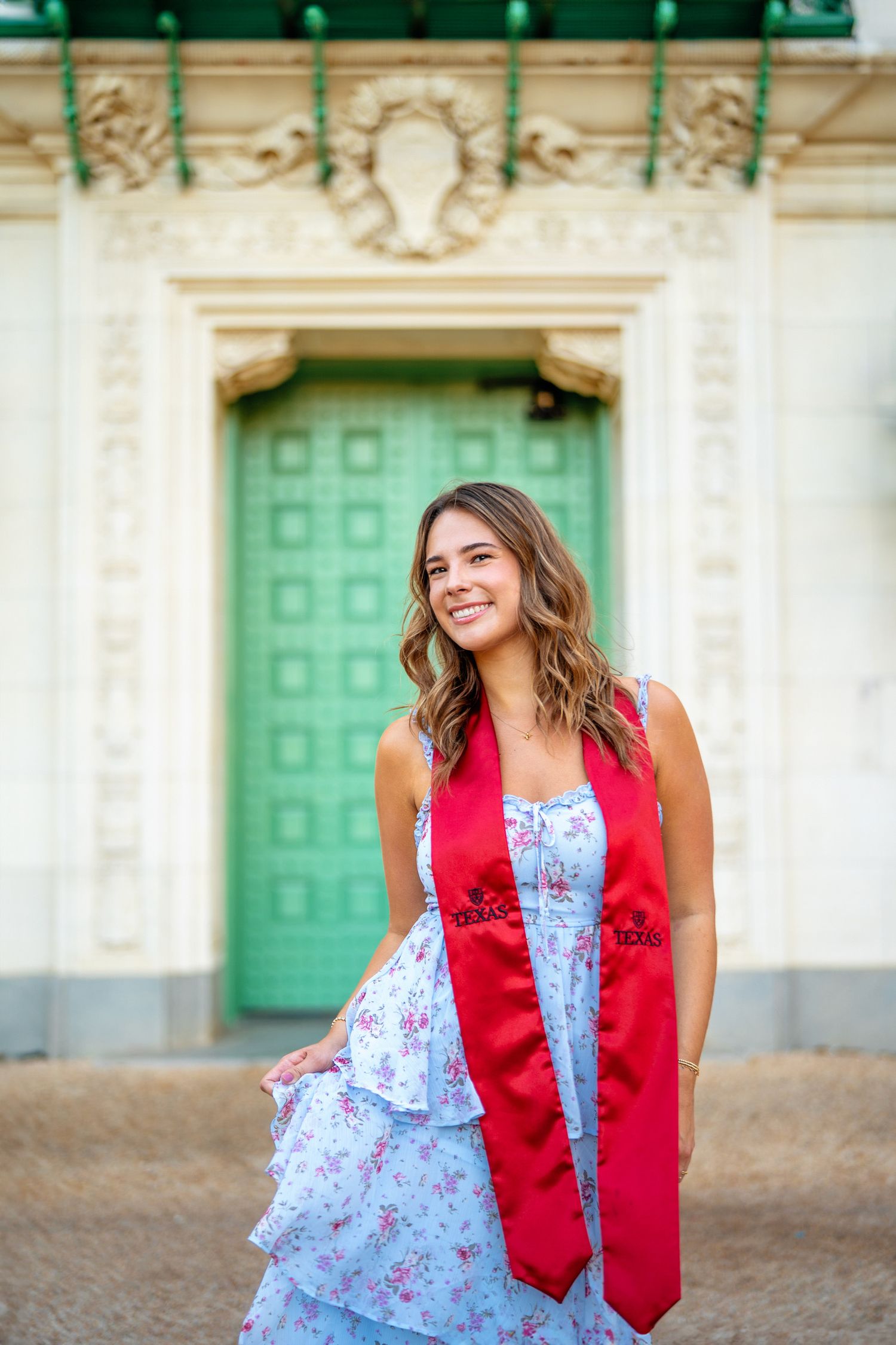 University of Texas graduation photo in front of green doors on campus