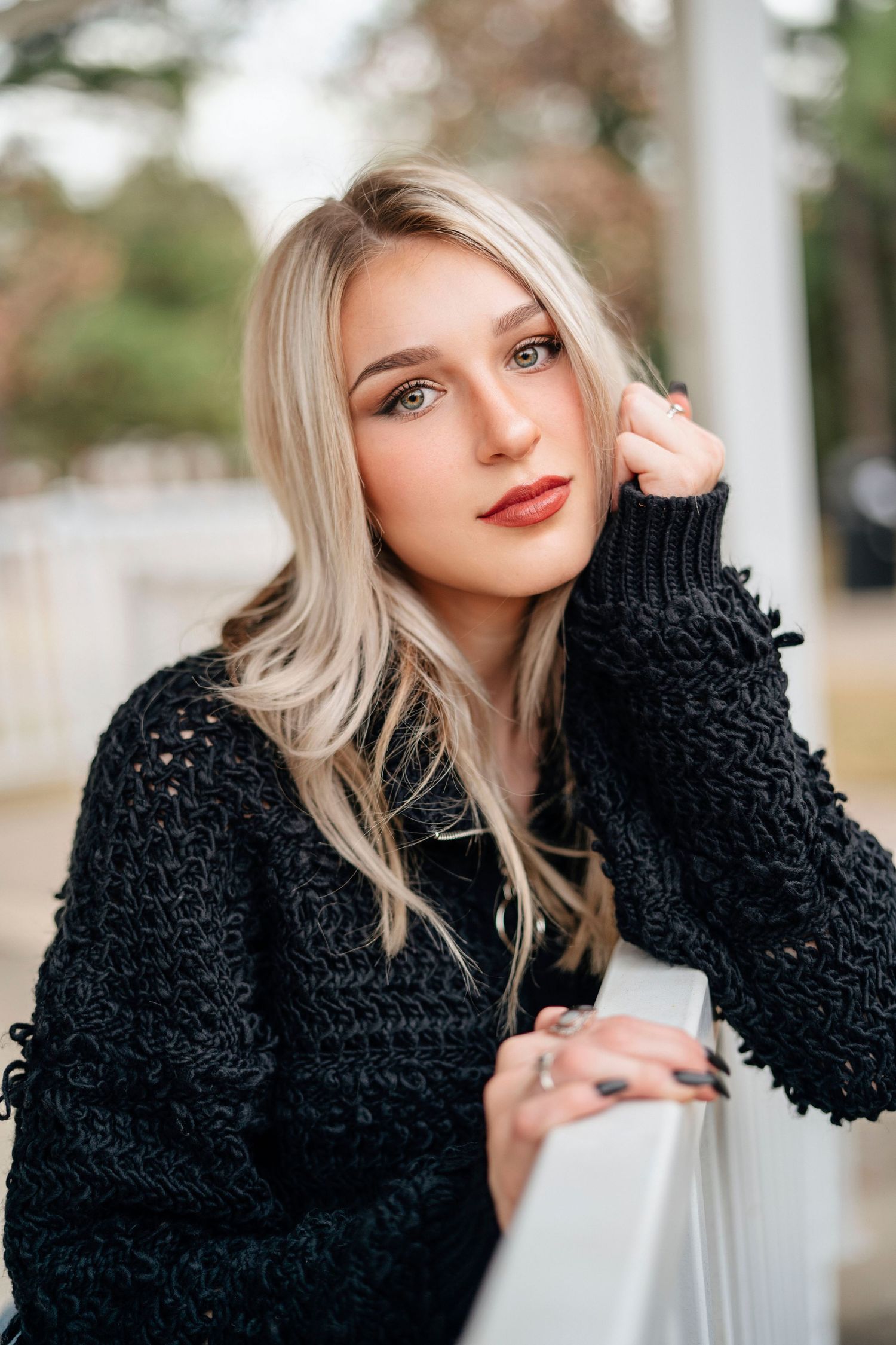 Close up portrait of someone in black knit sweater during autumn.