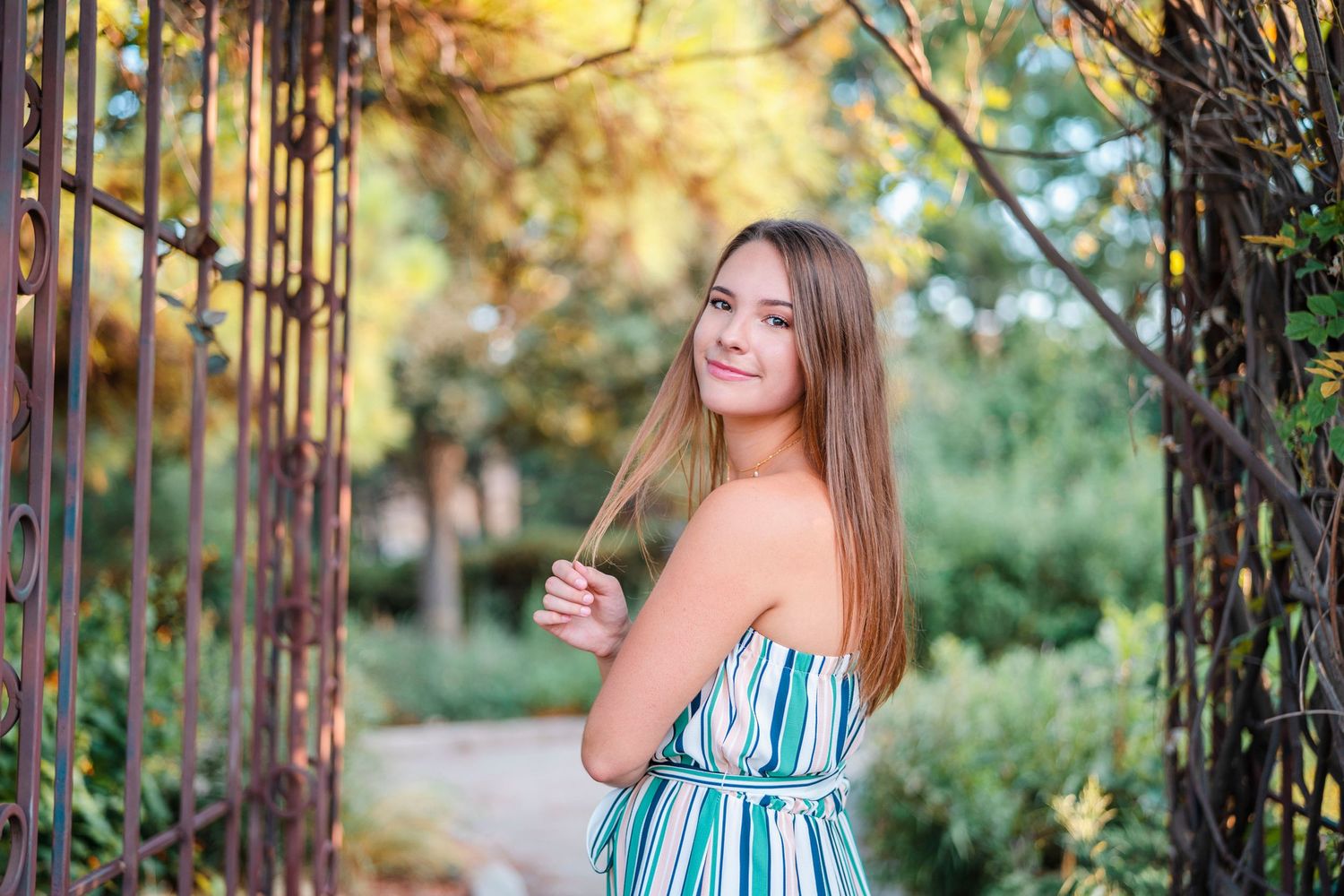 Summer portrait session among trees with golden hour lighting.