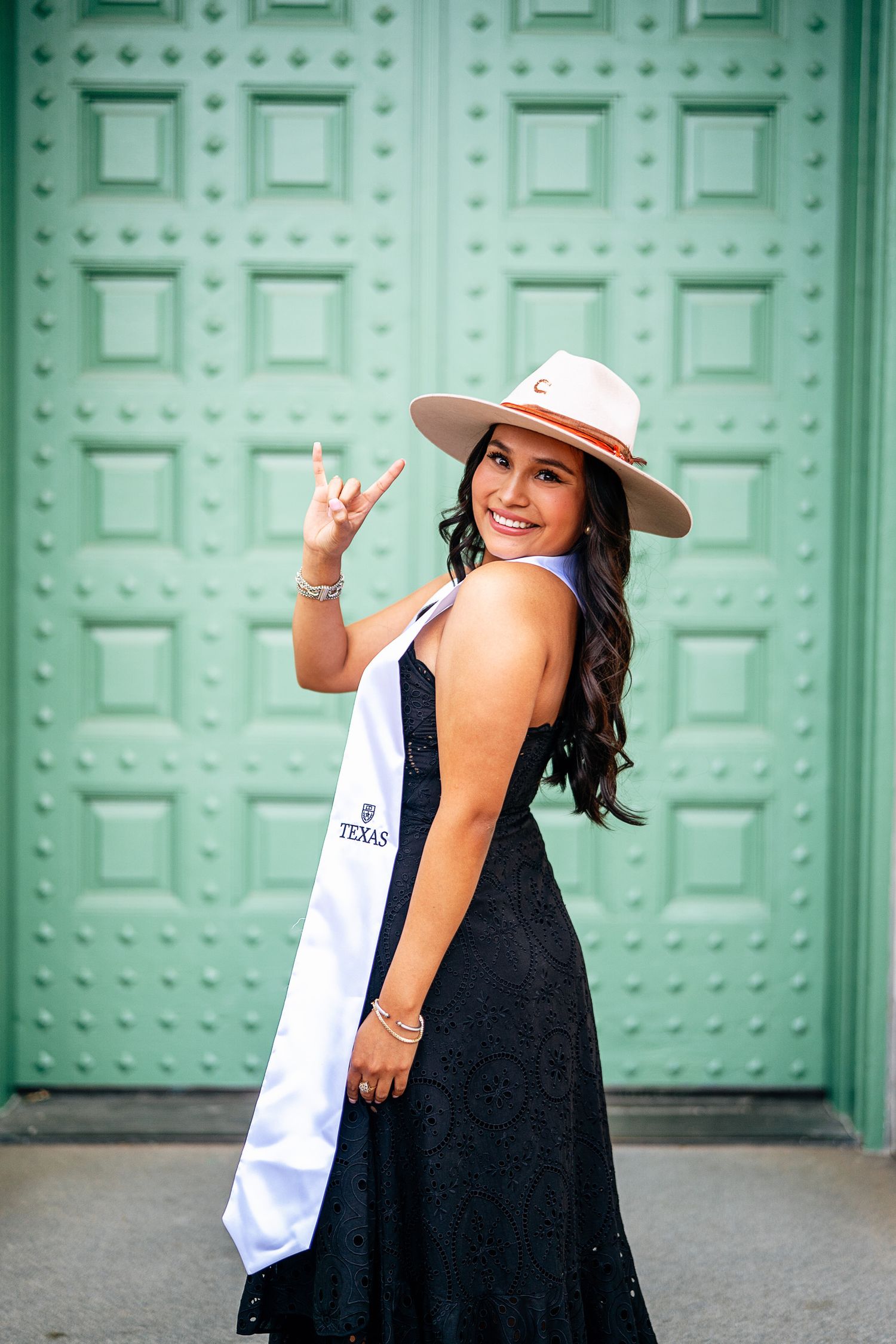 Graduation portrait by the historic green doors at UT’s Battle Hall, Blue doors.