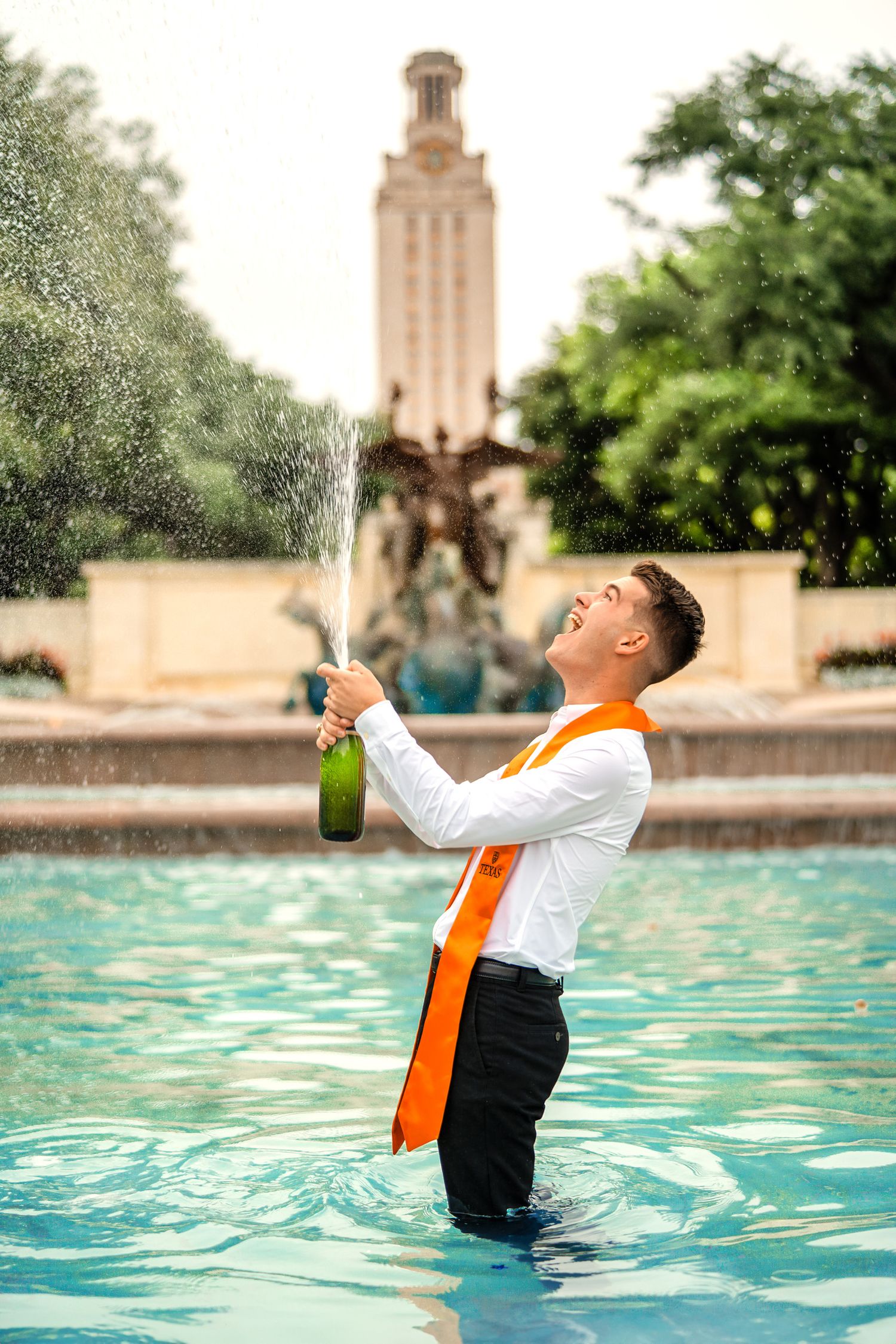 Golden hour UT Austin graduation portrait with champagne pop
