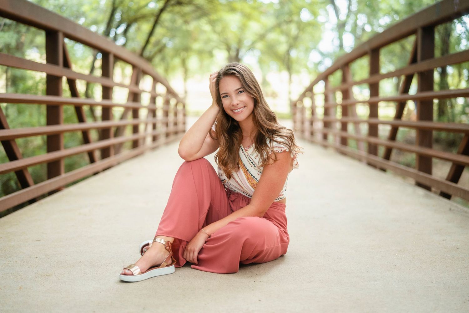 A series of relaxed poses on a wooden bridge walkway surrounded by greenery.
