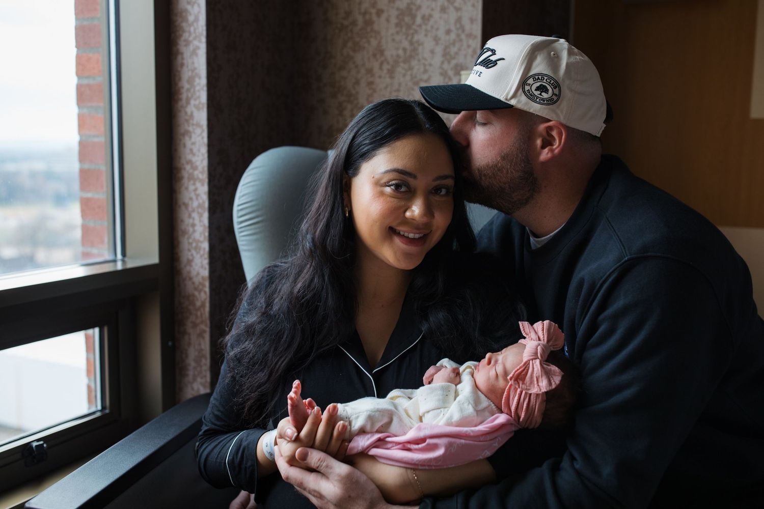 Parents sitting together holding their newborn during a quiet Fresh 48 session in Boise