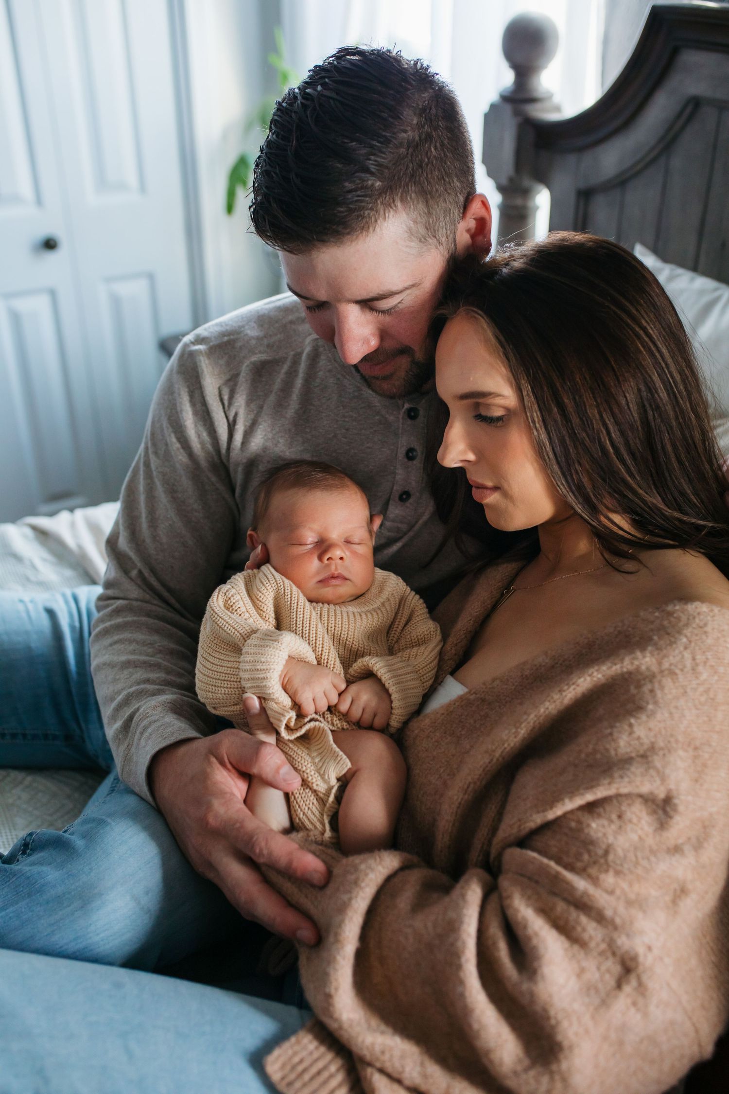 A couple in cozy brown sweaters share tender moments with their newborn baby in a series of intimate family photos - lifestyle newborn