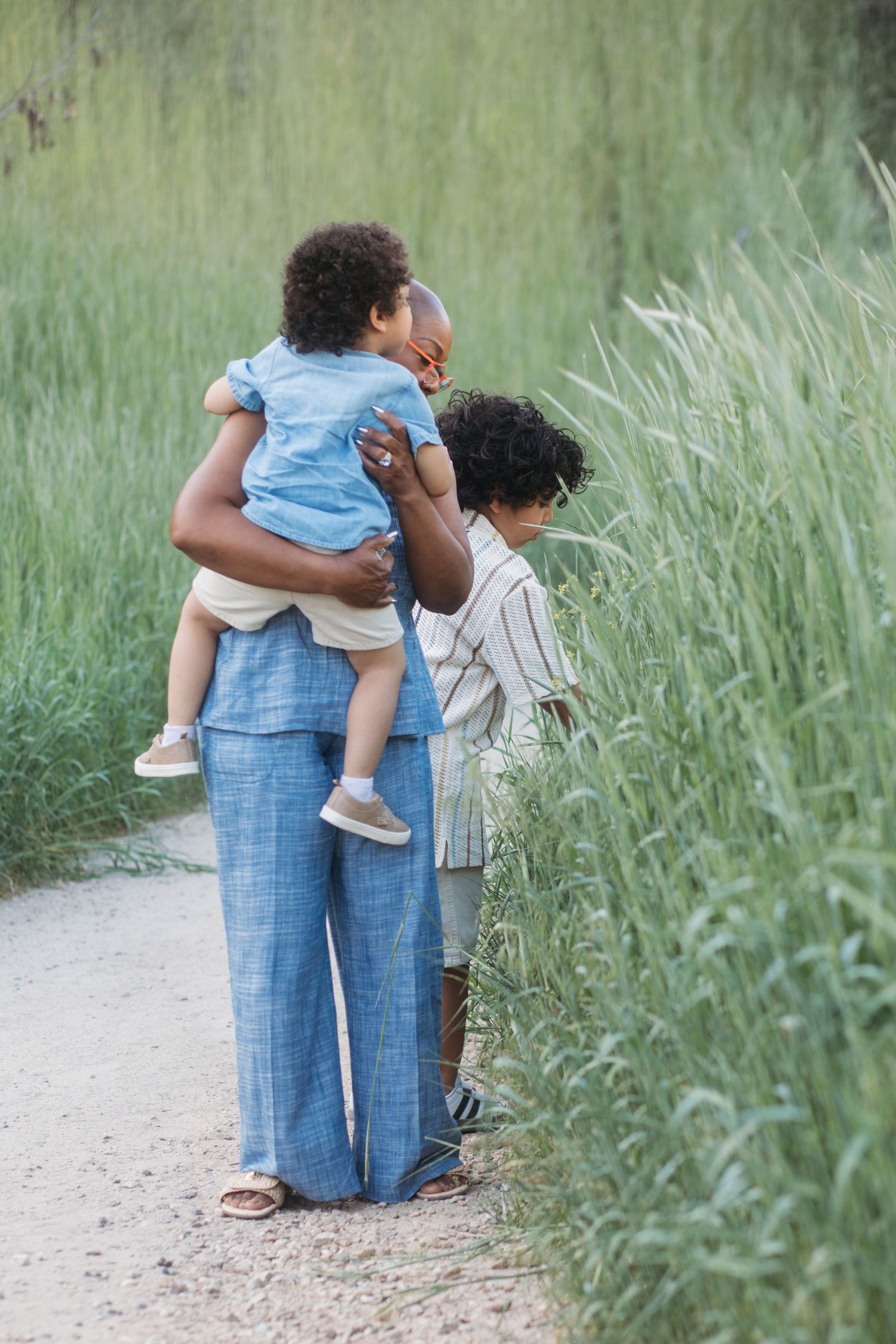 Candid moment of grandmother walking with grandchildren through Camel’s Back Park during an extended family session.