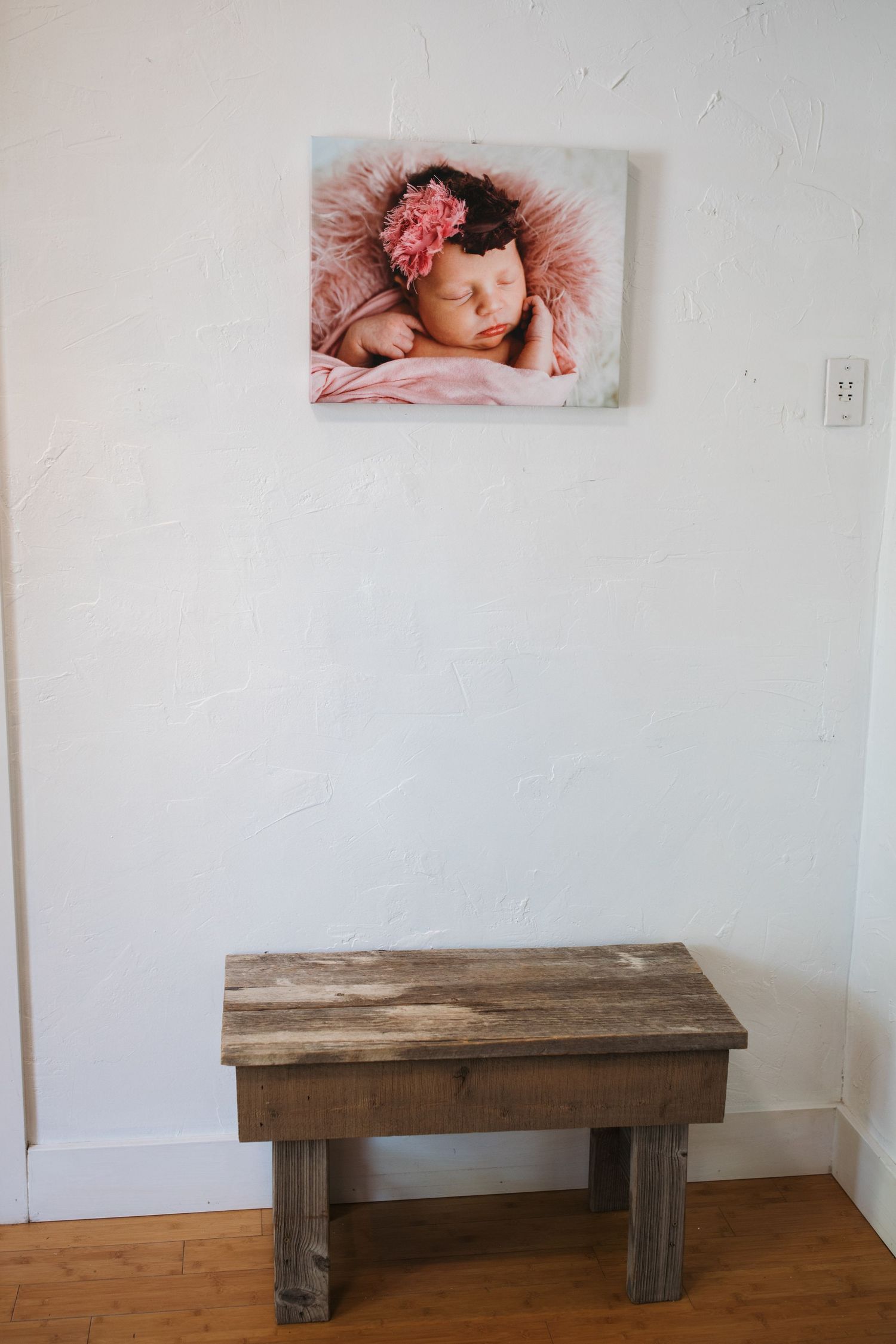 Cozy seating area with newborn artwork inside the Nampa photography studio.