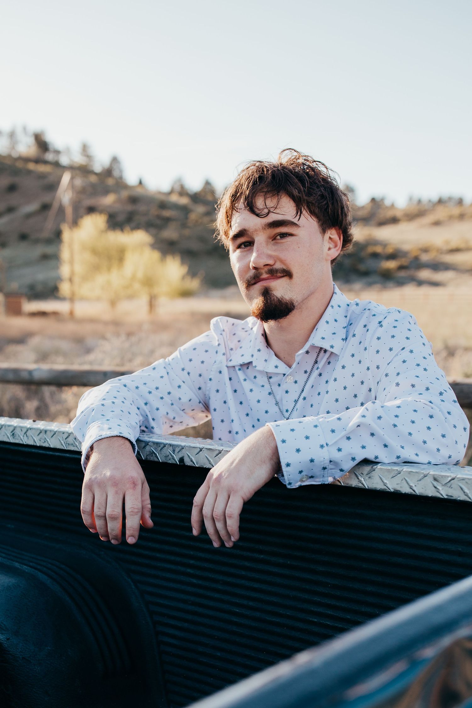 Close up senior portrait of high school boy leaning on truck bed during Boise Idaho senior photo session