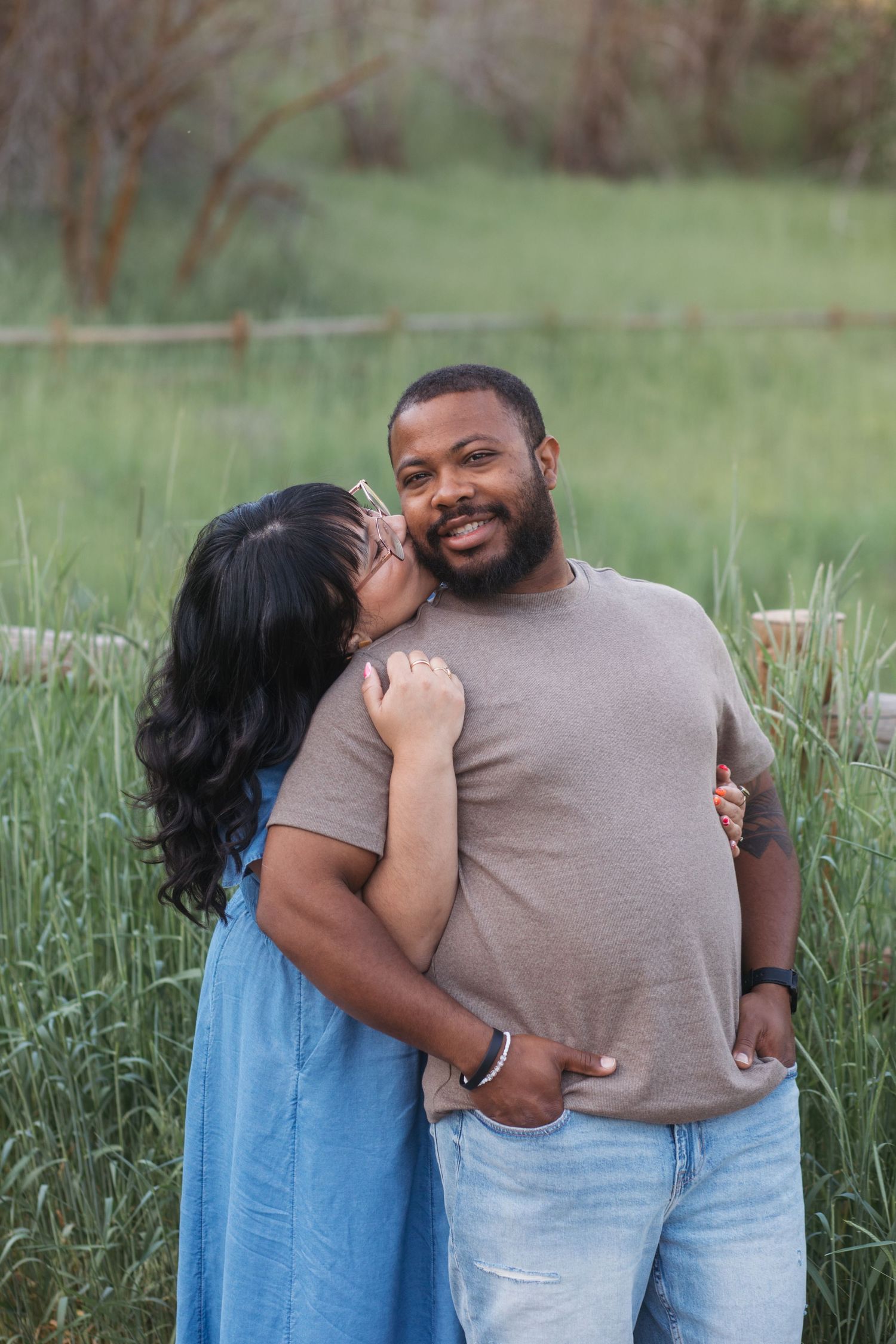 Wife kissing husband on the cheek during a spring family photography session at Camel’s Back Park in Boise.