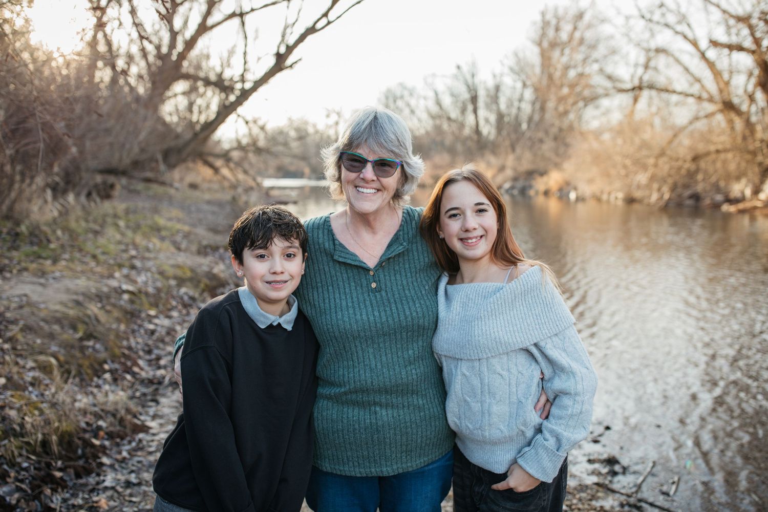 Grandmother smiling with her grandchildren during a lifestyle family photography session by the river in Idaho.
