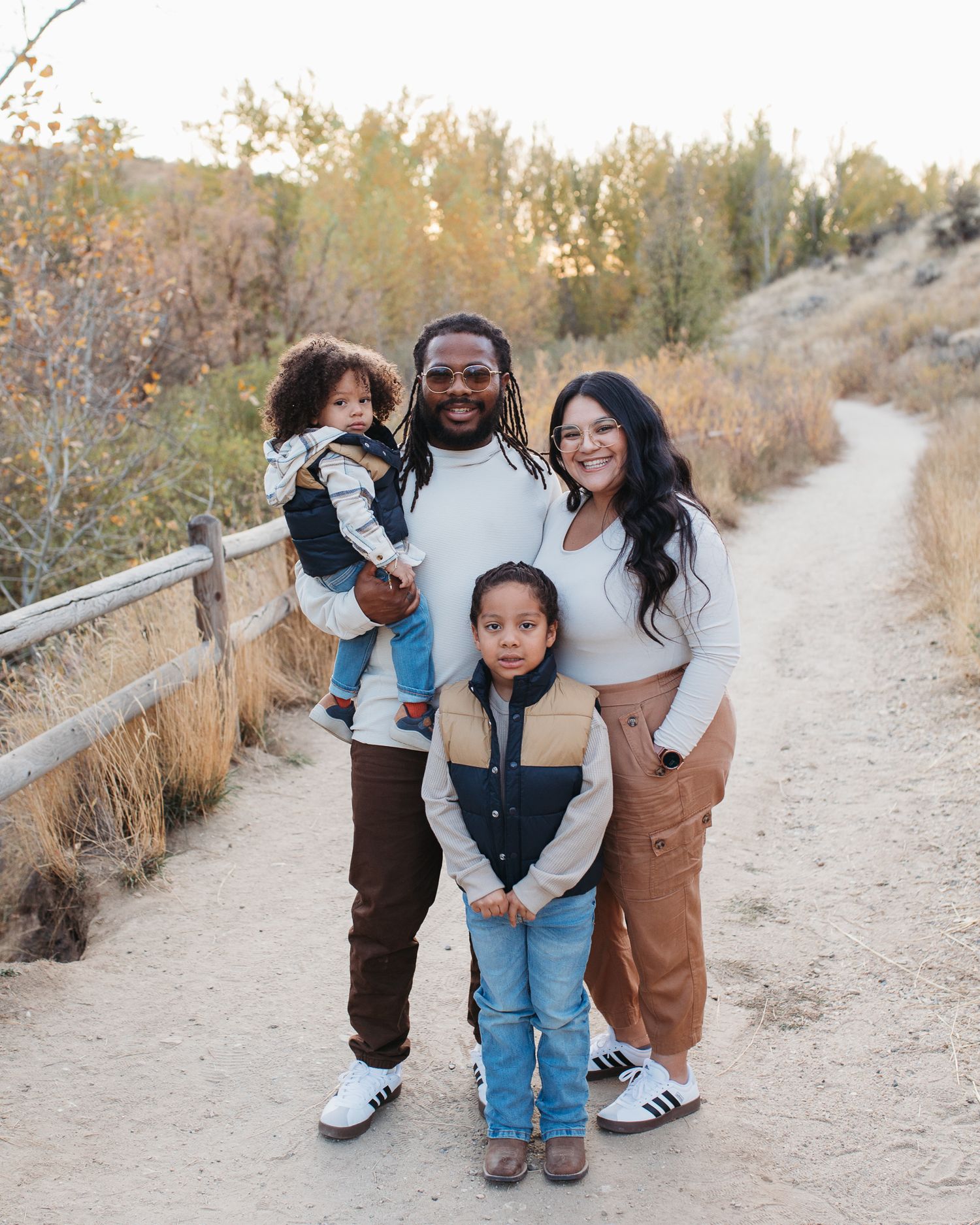 A family shares tender moments together while walking along a scenic desert trail on an autumn day in the foothills of Boise - lifestyle