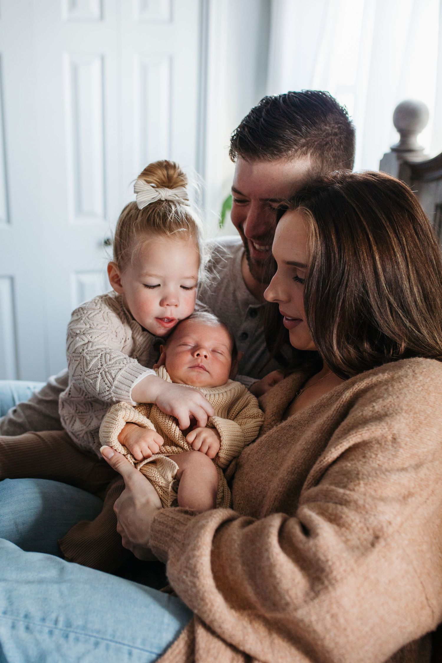 A family shares an intimate moment together on a couch while bonding with their newborn baby - lifestyle in-home newborn photos Boise