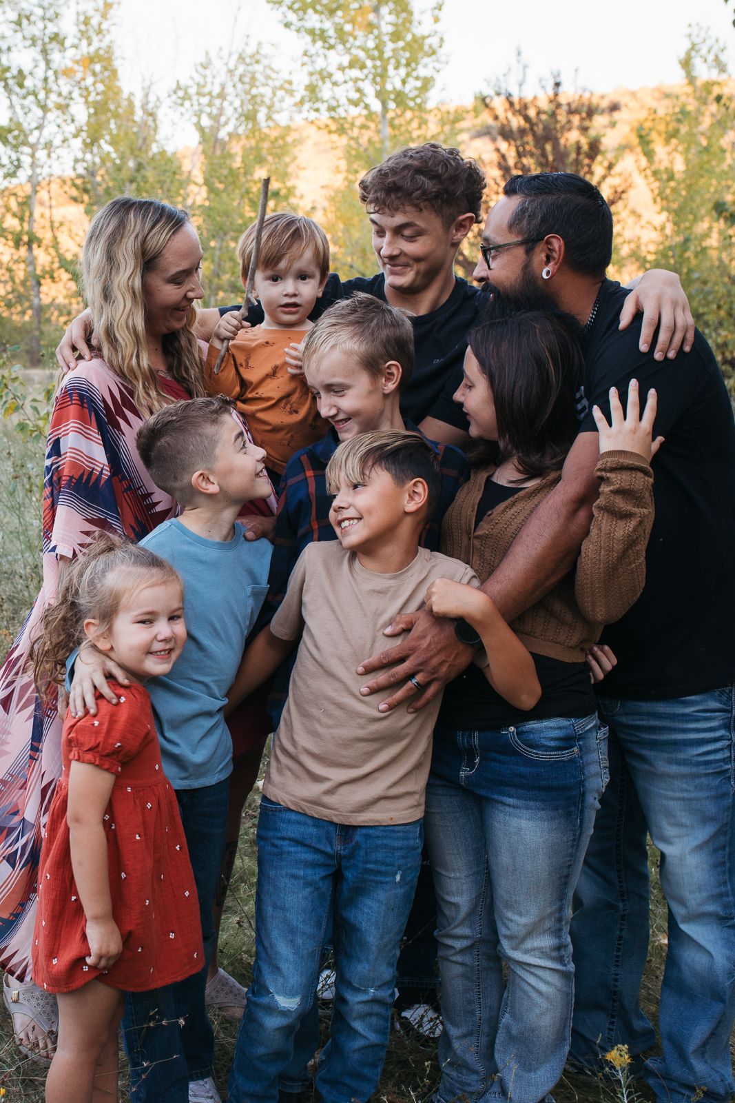 A candid family photo series showing joyful group interactions outdoors during golden hour - lifestyle family photography Boise