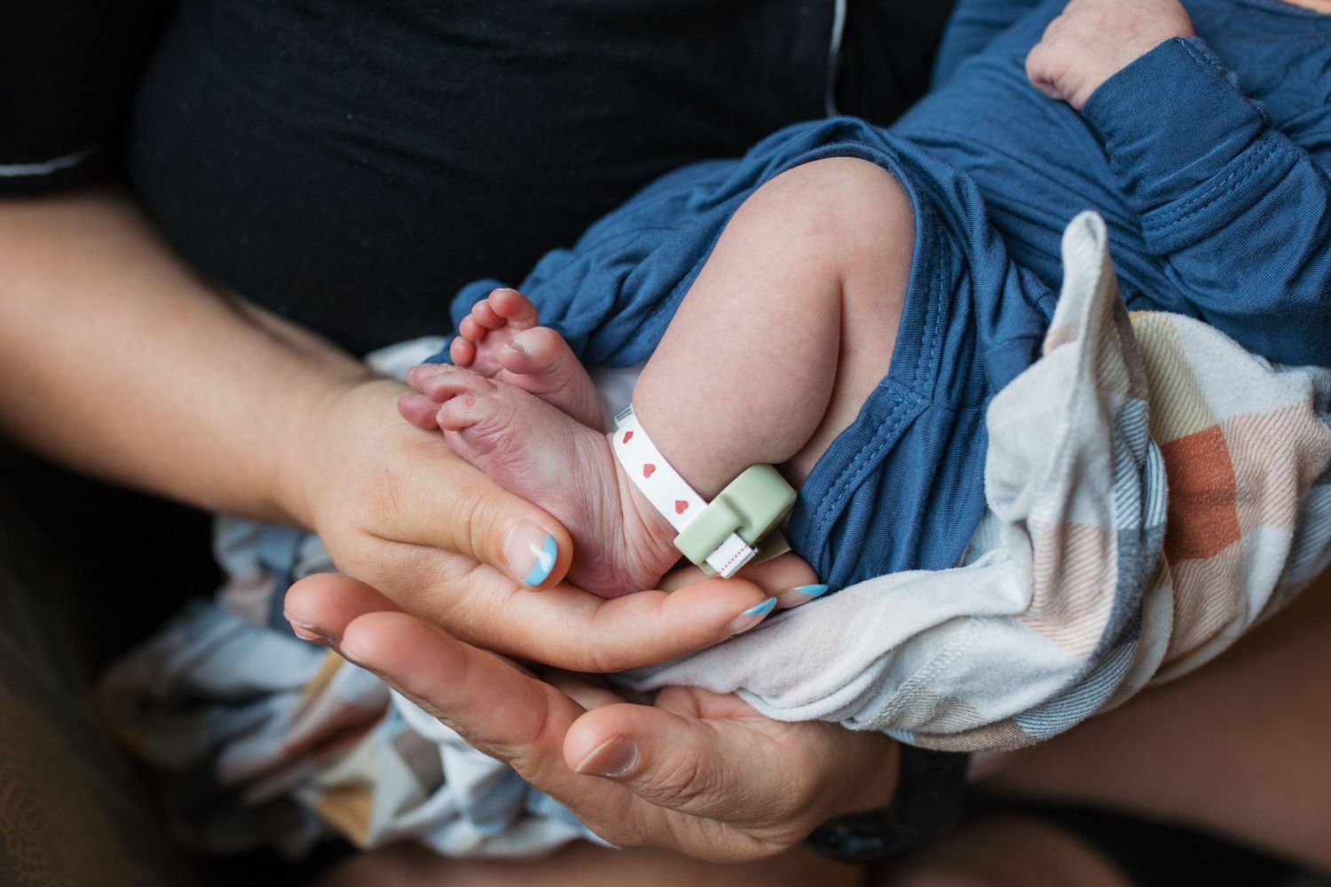 close up of mom and dad holding newborn feet - Fresh 48 session in Boise, Idaho