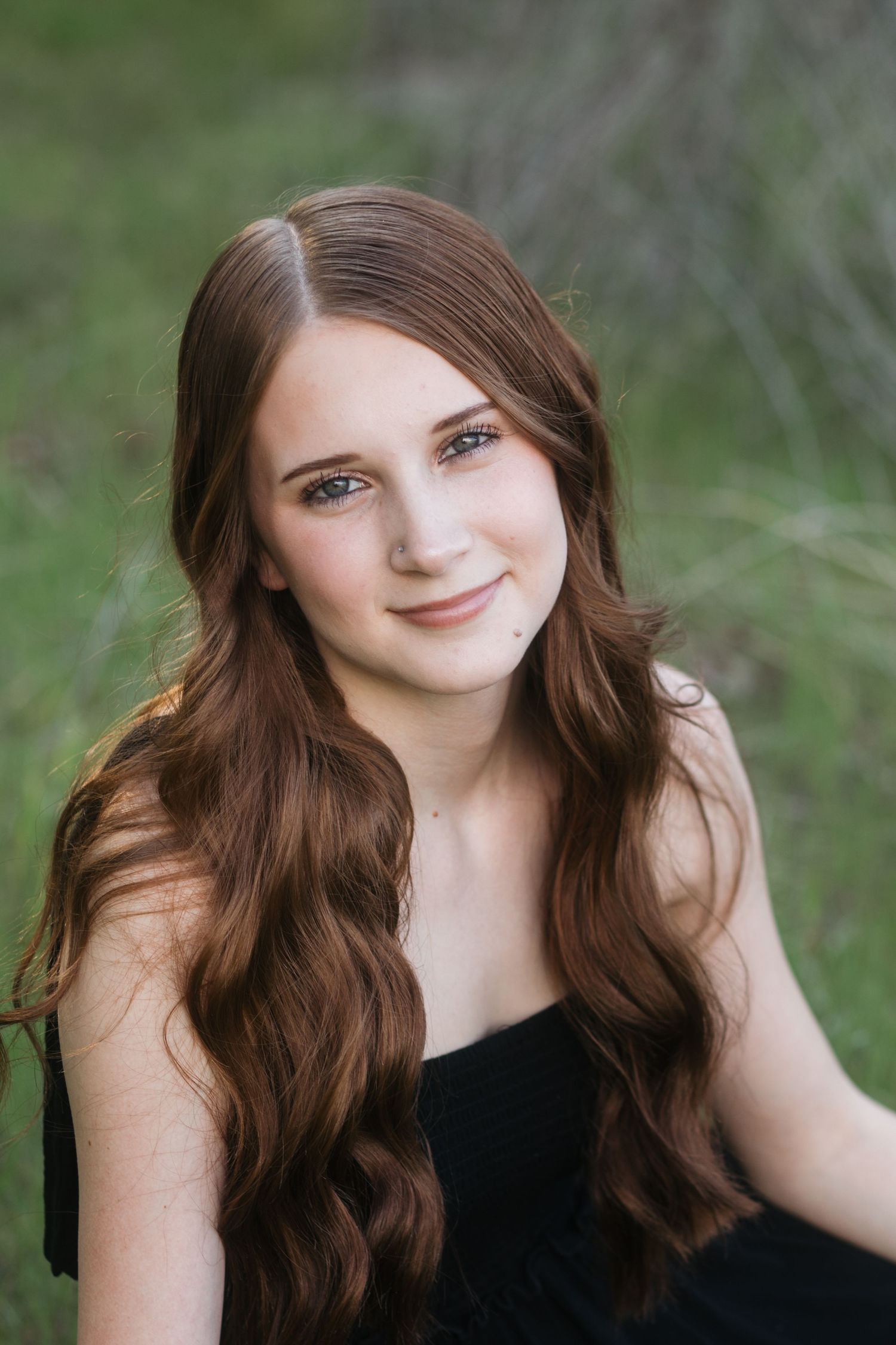 Boise senior portrait of high school girl with long wavy hair in soft natural light outdoor setting