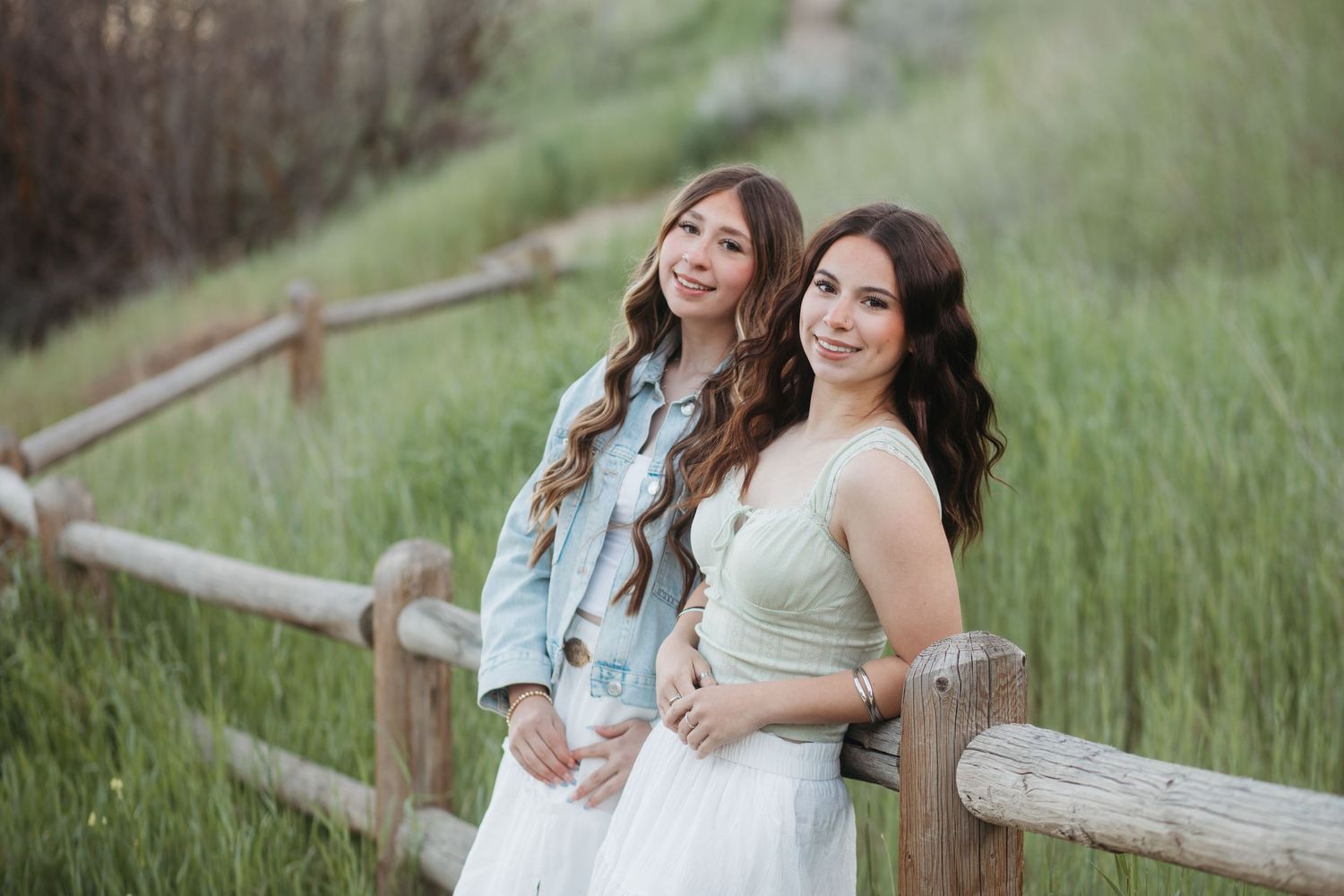 Two best friends posing together in a field for Boise senior photo session