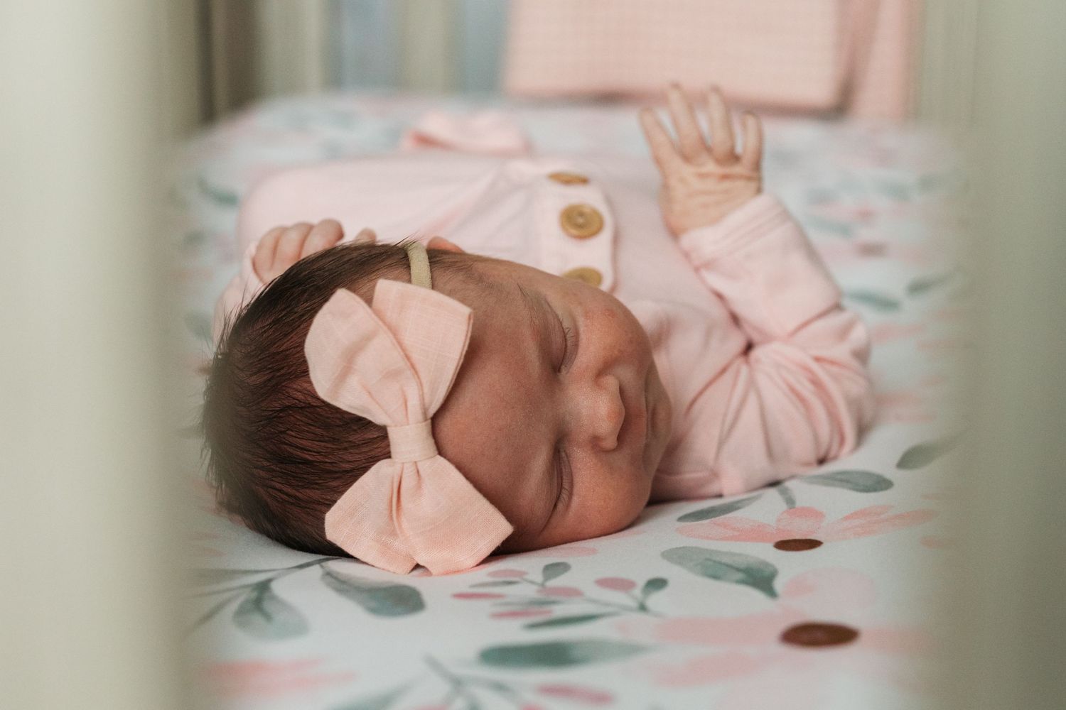 Sleeping newborn baby girl in pink outfit during lifestyle newborn session in Boise, Idaho