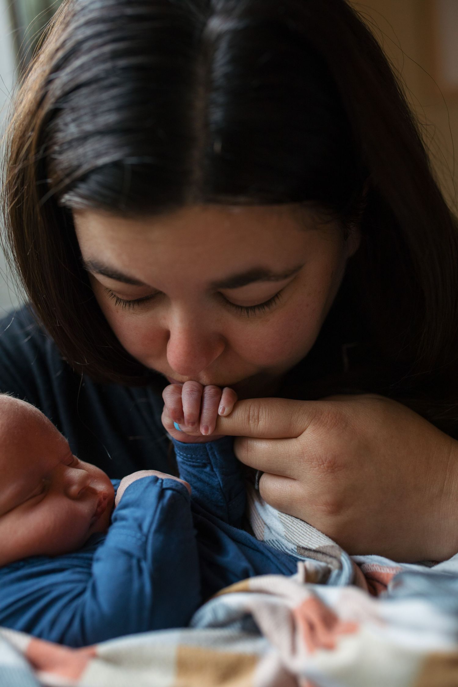 A close-up sequence showing someone gently kissing a sleeping newborn babys hand Fresh 48 session by Sara Elizabeth Photography Boise Idaho