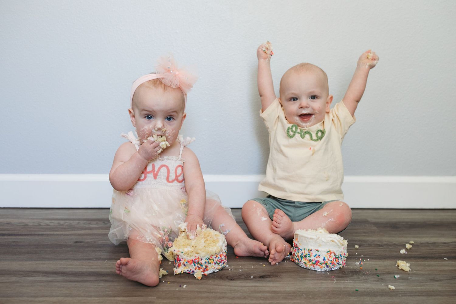 Twin first birthday cake smash session in Kuna, Idaho featuring one year old twins celebrating with birthday cake.